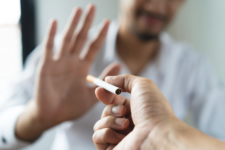 A man rejecting a cigarette with a hand gesture.