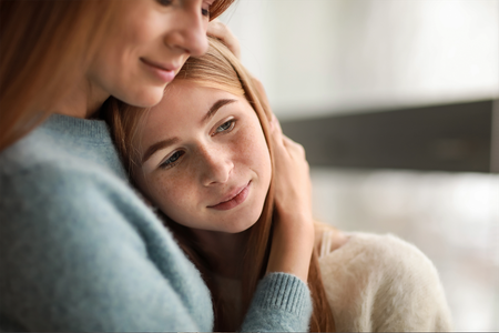 A woman is hugging a young girl.