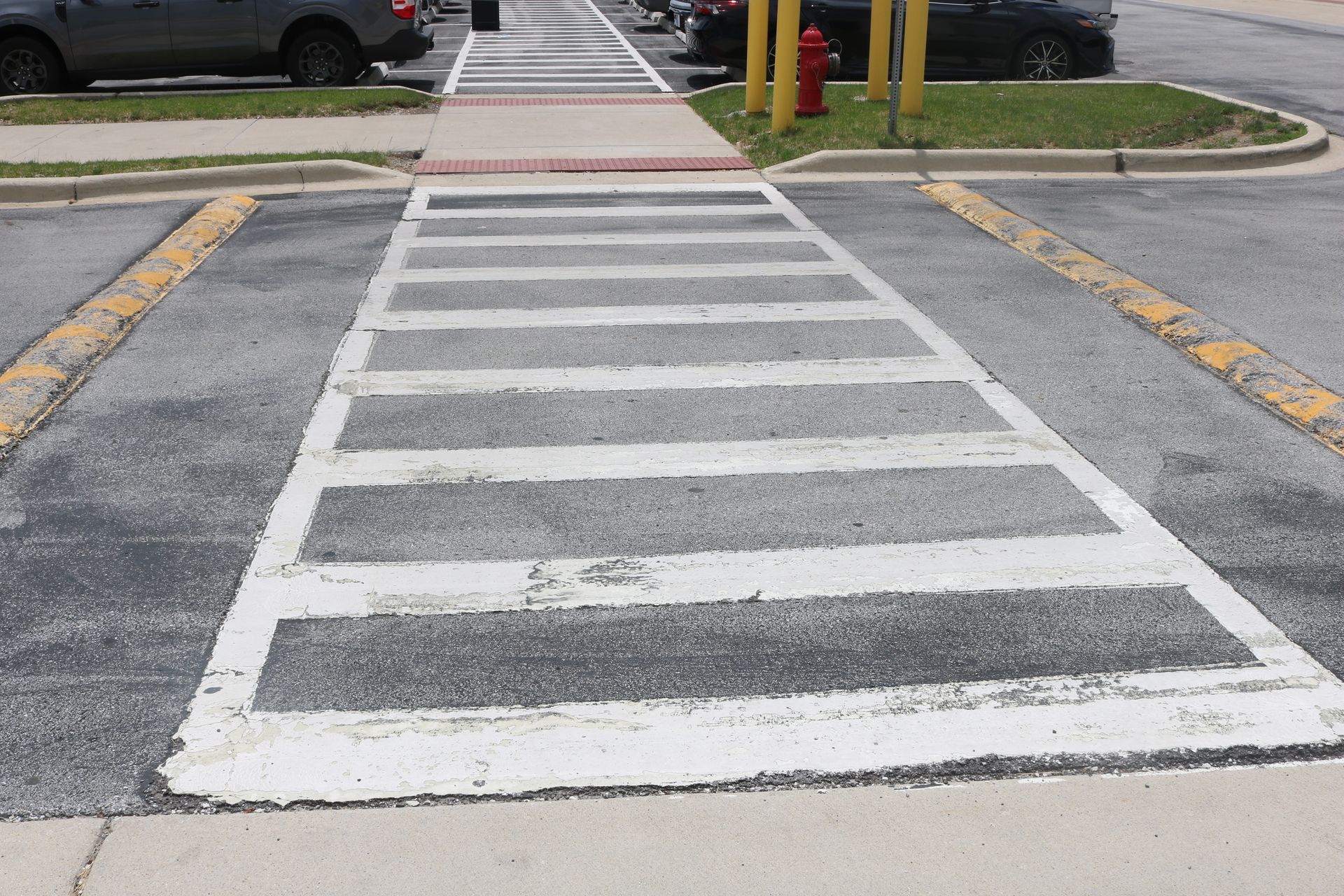 A crosswalk with a fire hydrant in the background.