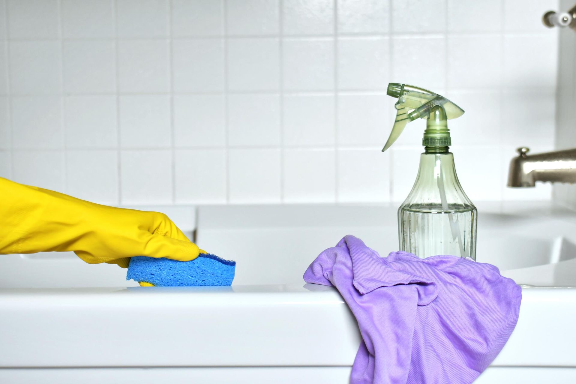 image of a gloved person scrubbing the tub clean