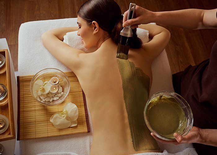 Beauty — Cosmetologist Putting a Mask on Woman's Back in Scottsdale, AZ