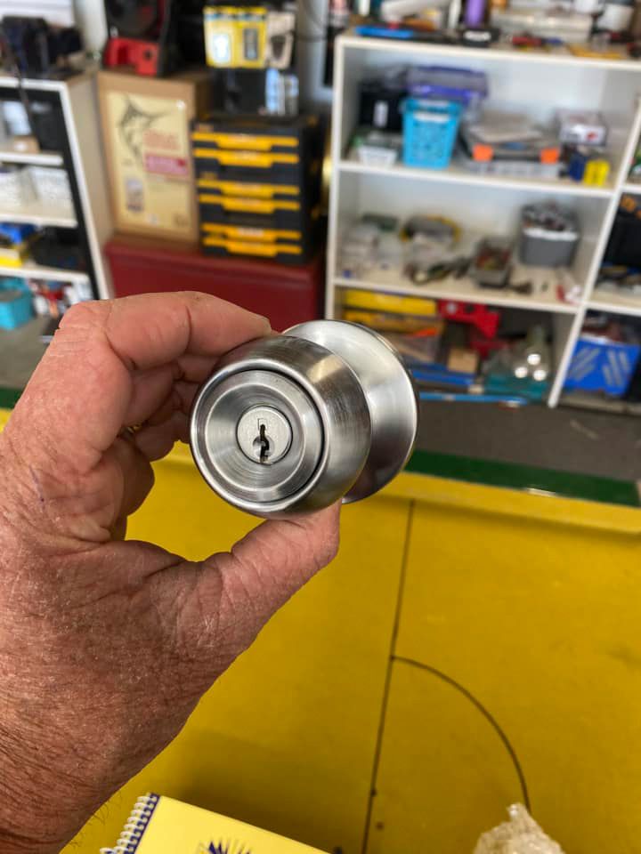 A Person Is Holding A Stainless Steel Door Knob In Their Hand — ClarKEYS Mobile Locksmiths In Winter Valley, VIC