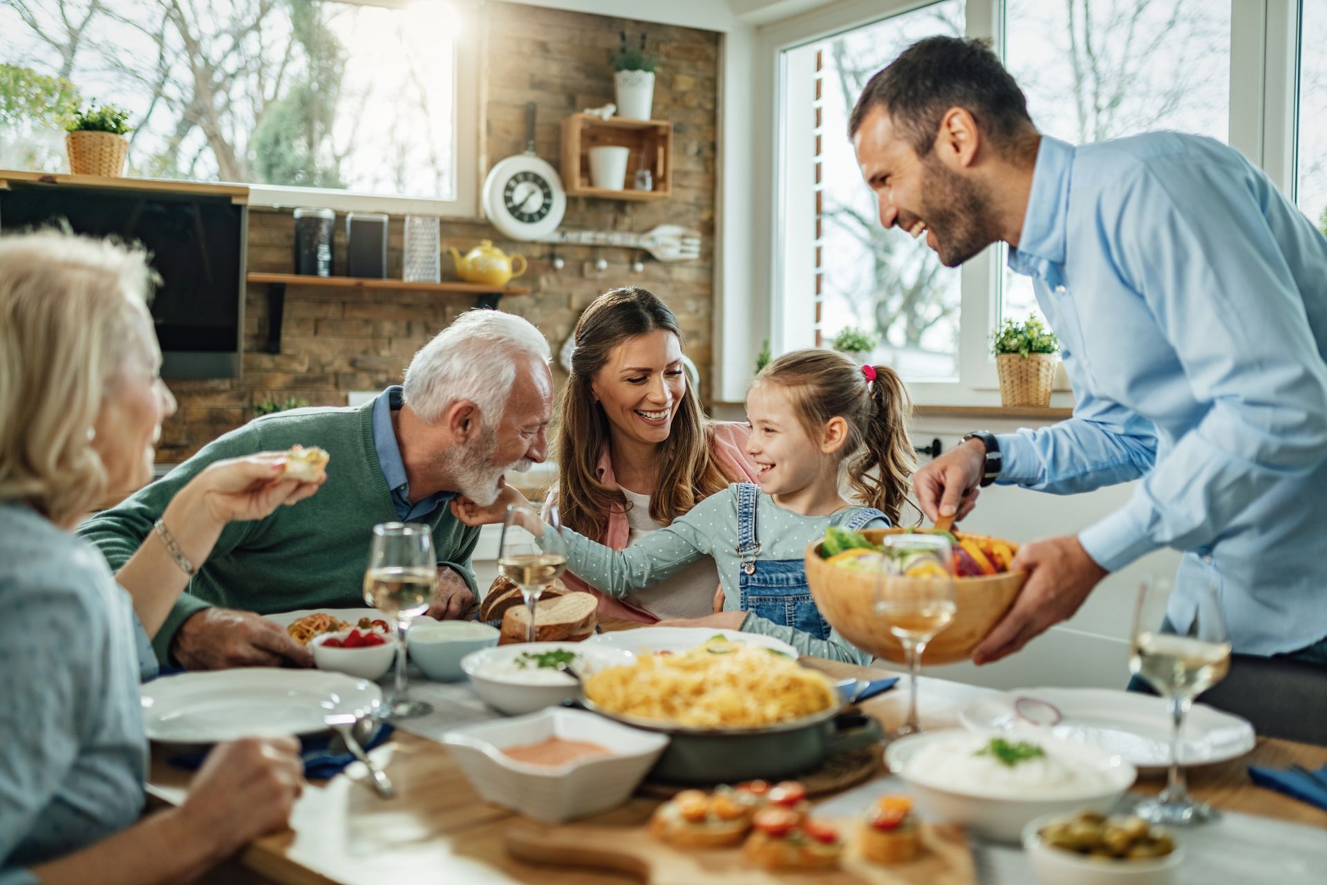 A family is sitting at a table eating food.
