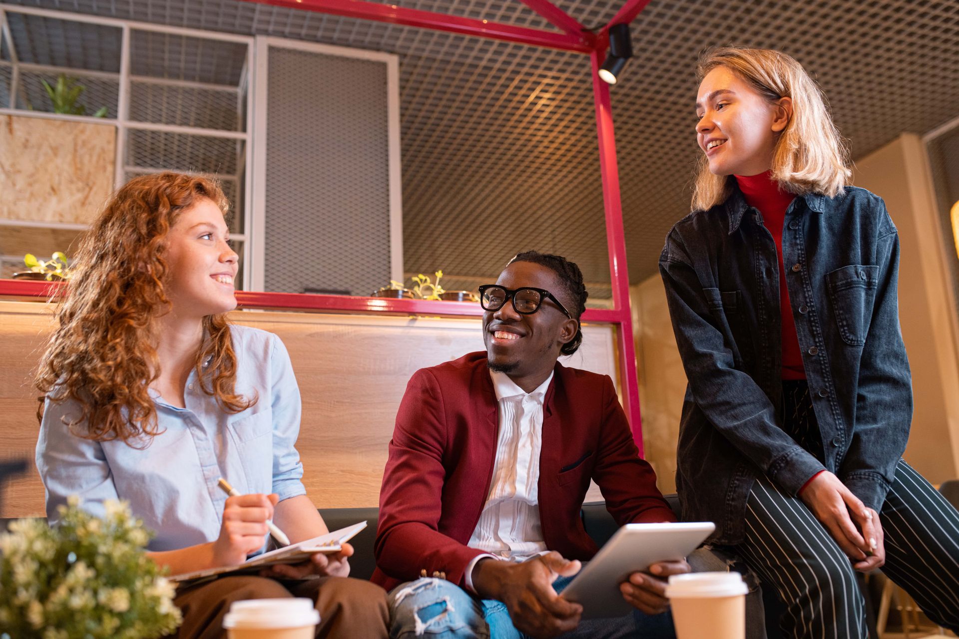 A group of people are sitting on a couch talking to each other.