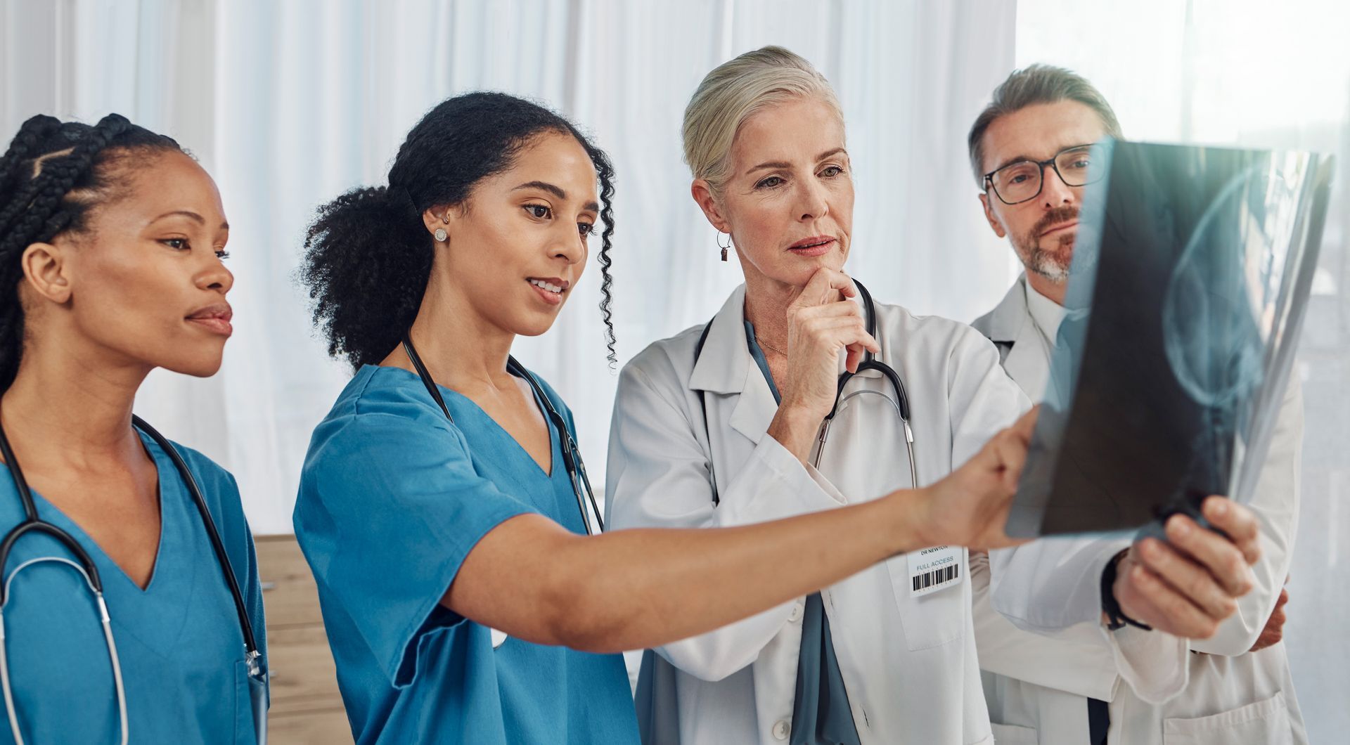 A group of doctors and nurses are looking at an x-ray.