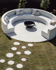 A round couch with a fire pit in the middle of it