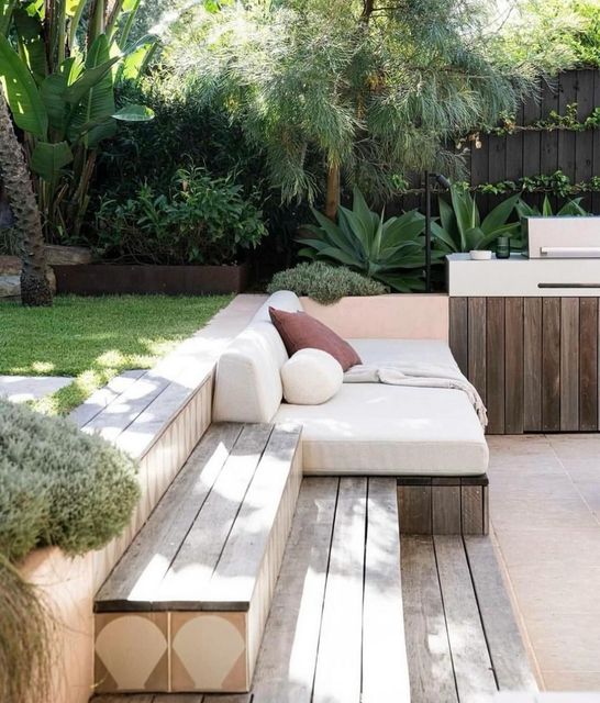 A patio with a white couch and a wooden bench