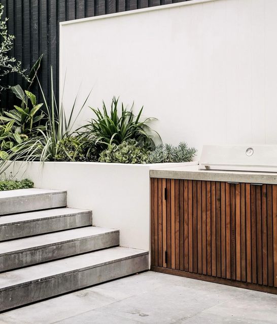 A patio with stairs leading up to a wooden cabinet.