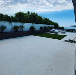 A patio with a view of the ocean and trees