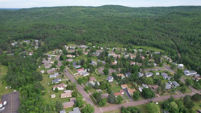 Aerial view of a residential neighborhood nestled in a green forest.