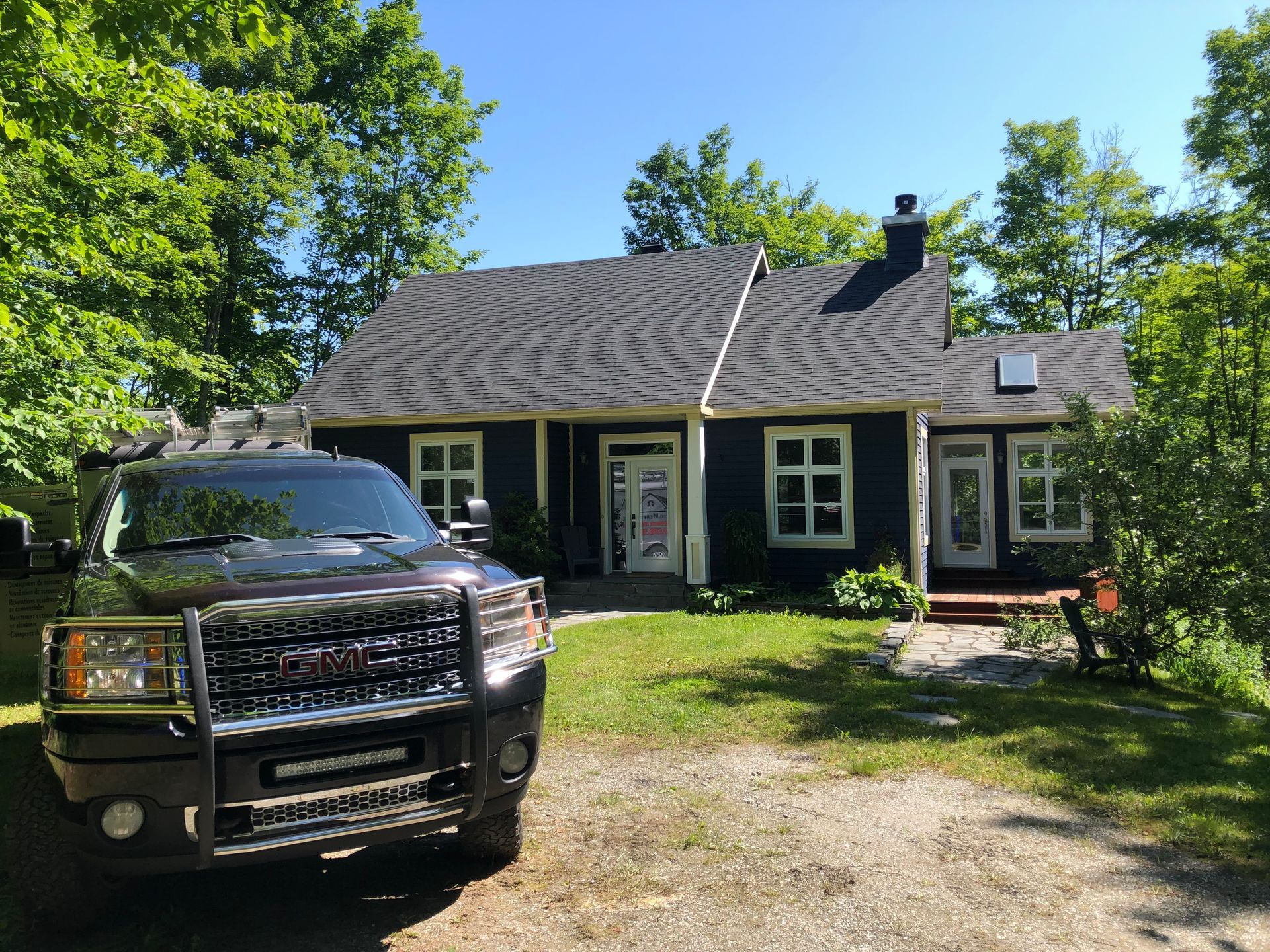 Un camion noir est garé devant une maison noire.