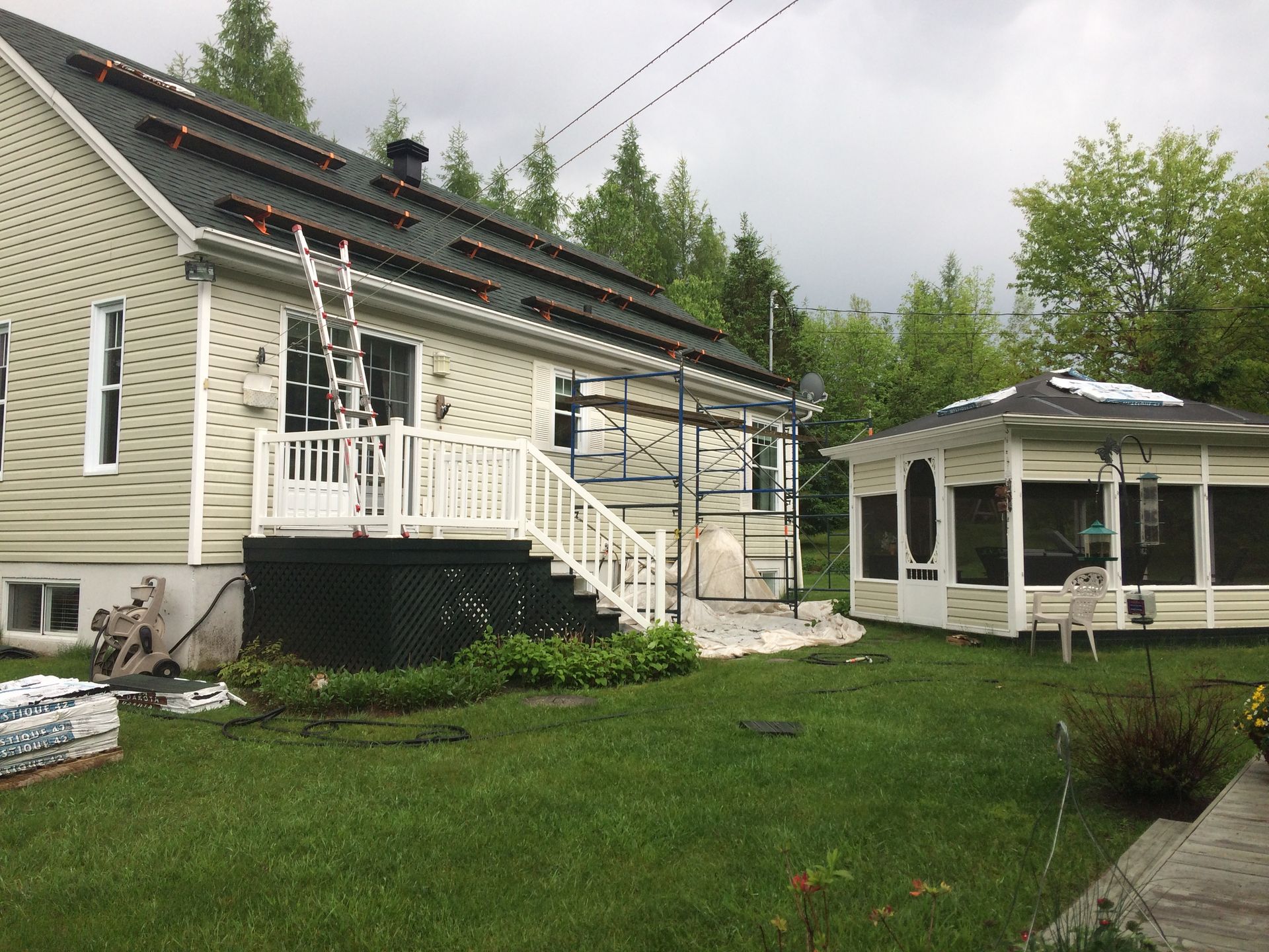 Une maison avec un porche grillagé et un belvédère dans l'arrière-cour.