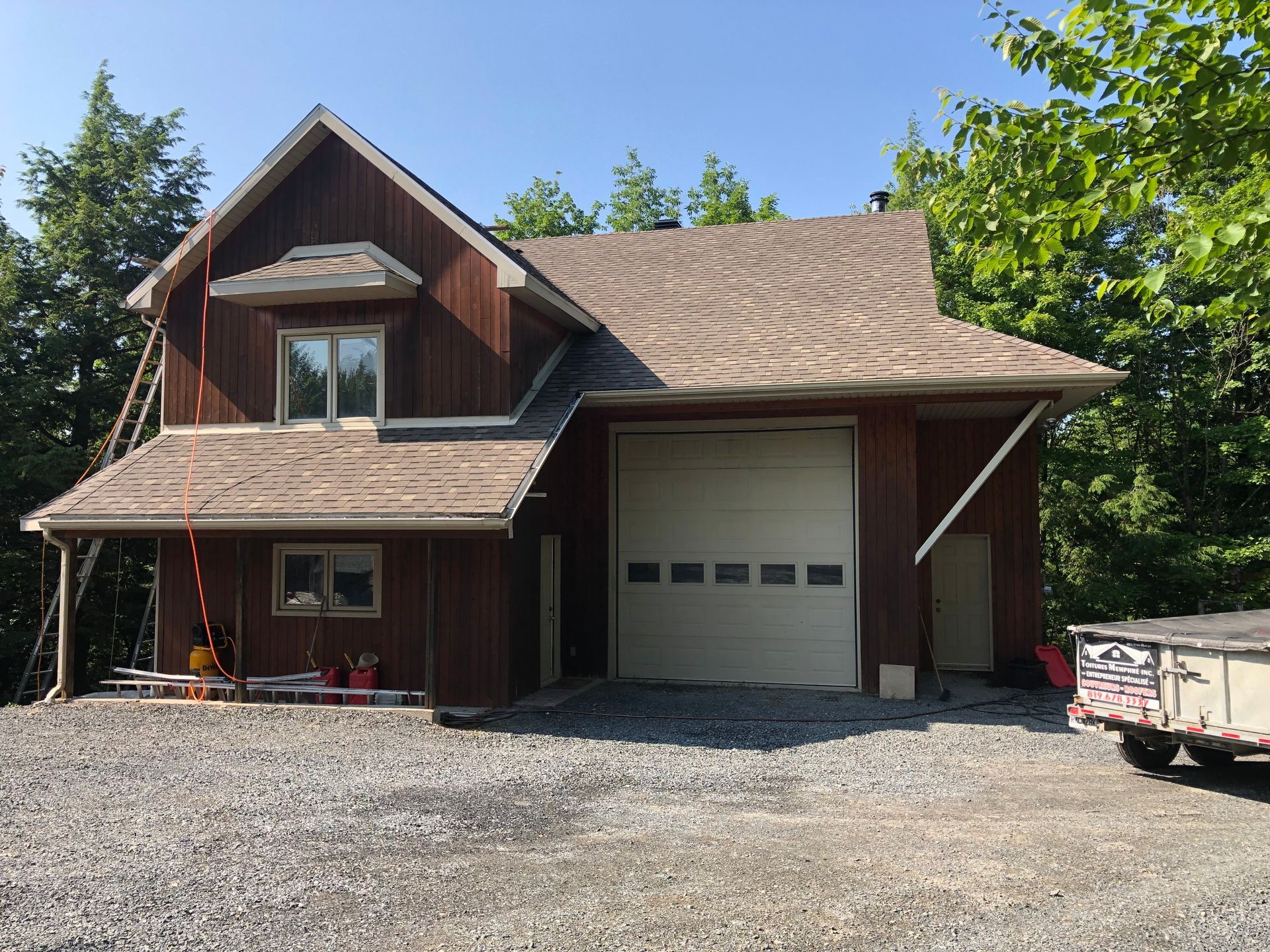 Une maison avec un garage et une caravane garée devant