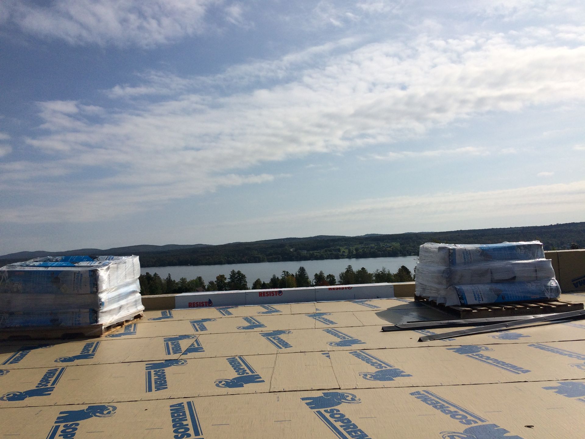 Un toit avec beaucoup de boîtes dessus et un lac en arrière-plan