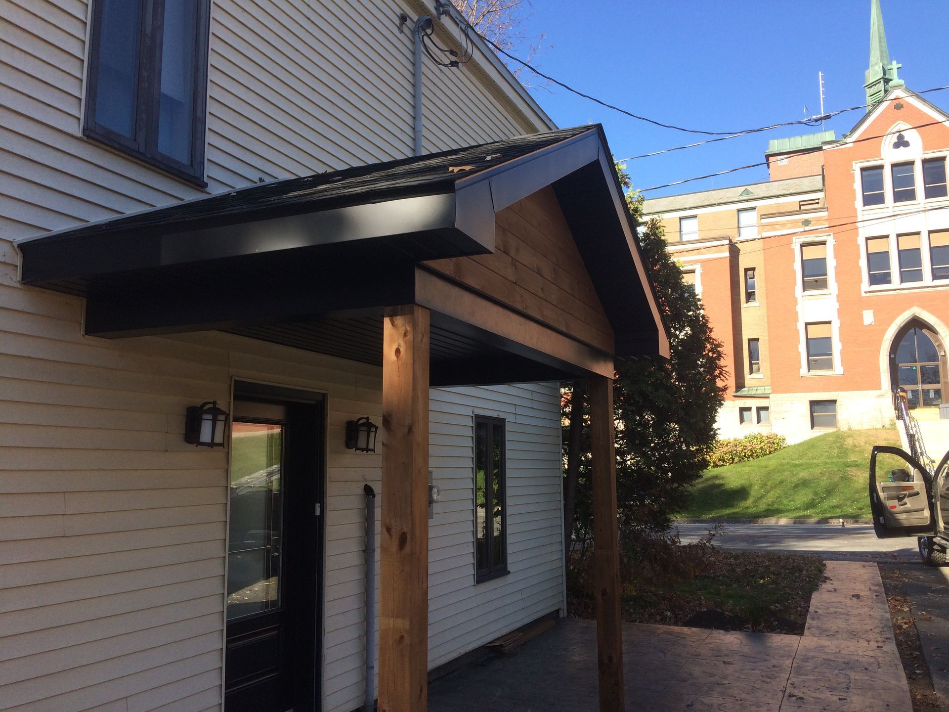 Une maison avec un porche et une église en arrière-plan