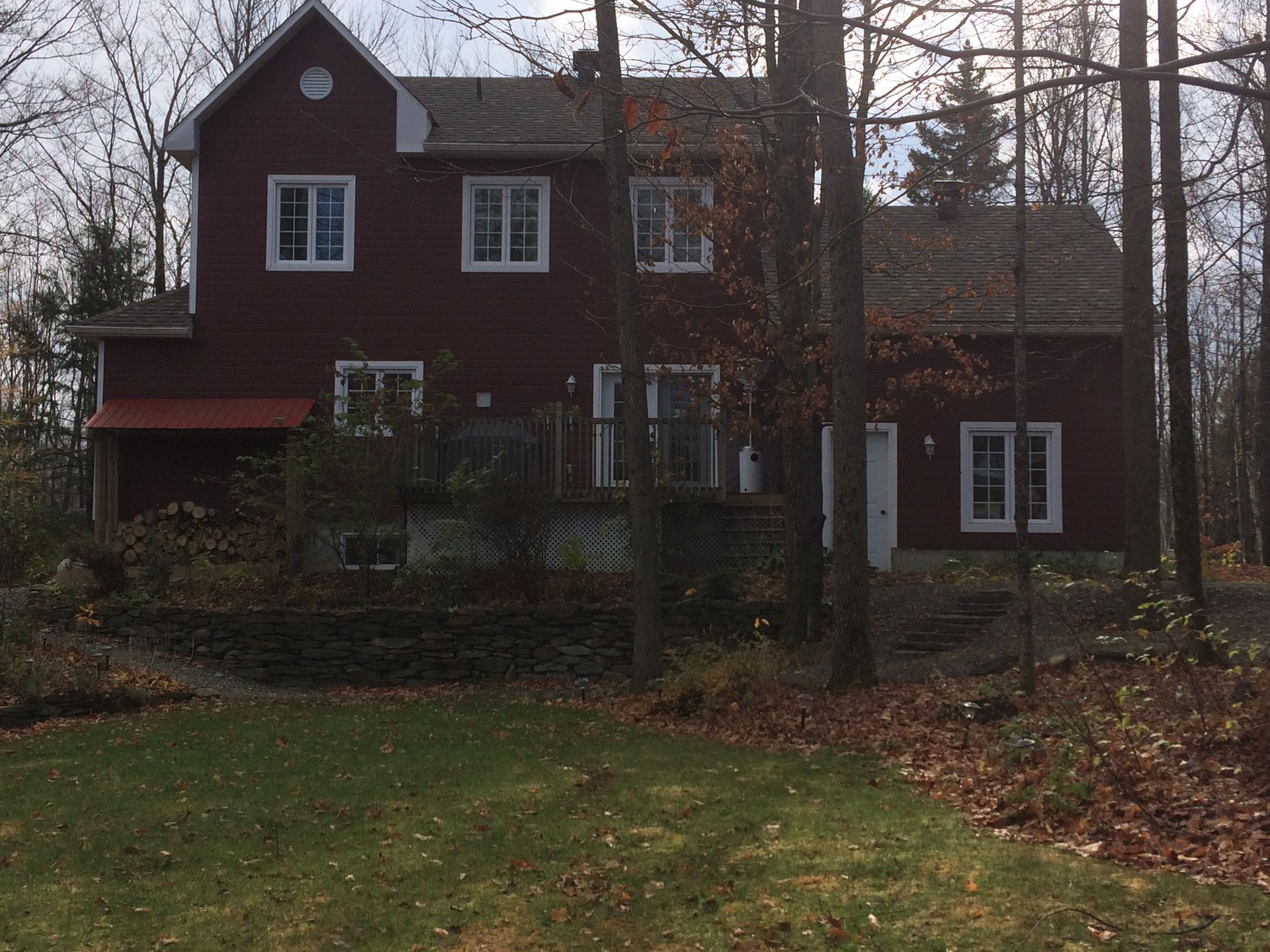Une grande maison rouge se trouve au milieu d'une forêt