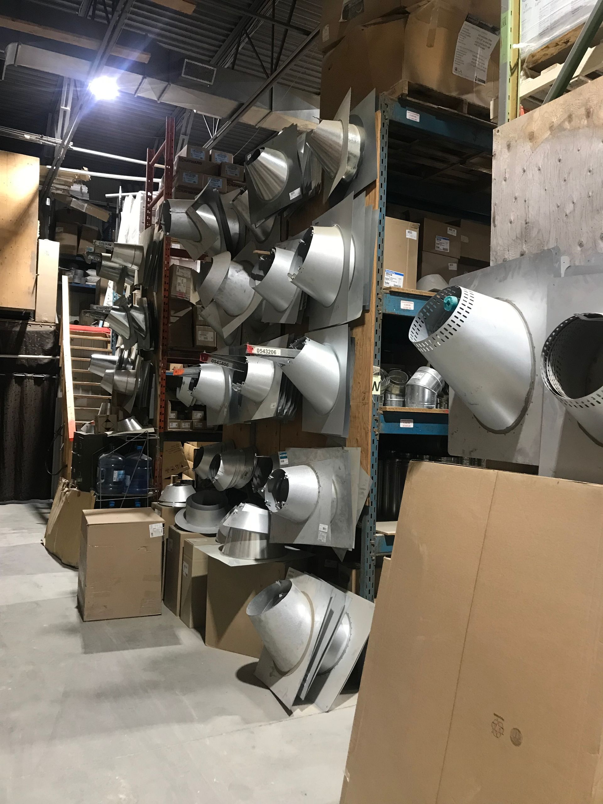 Un entrepôt rempli de beaucoup de boîtes et d'objets métalliques.