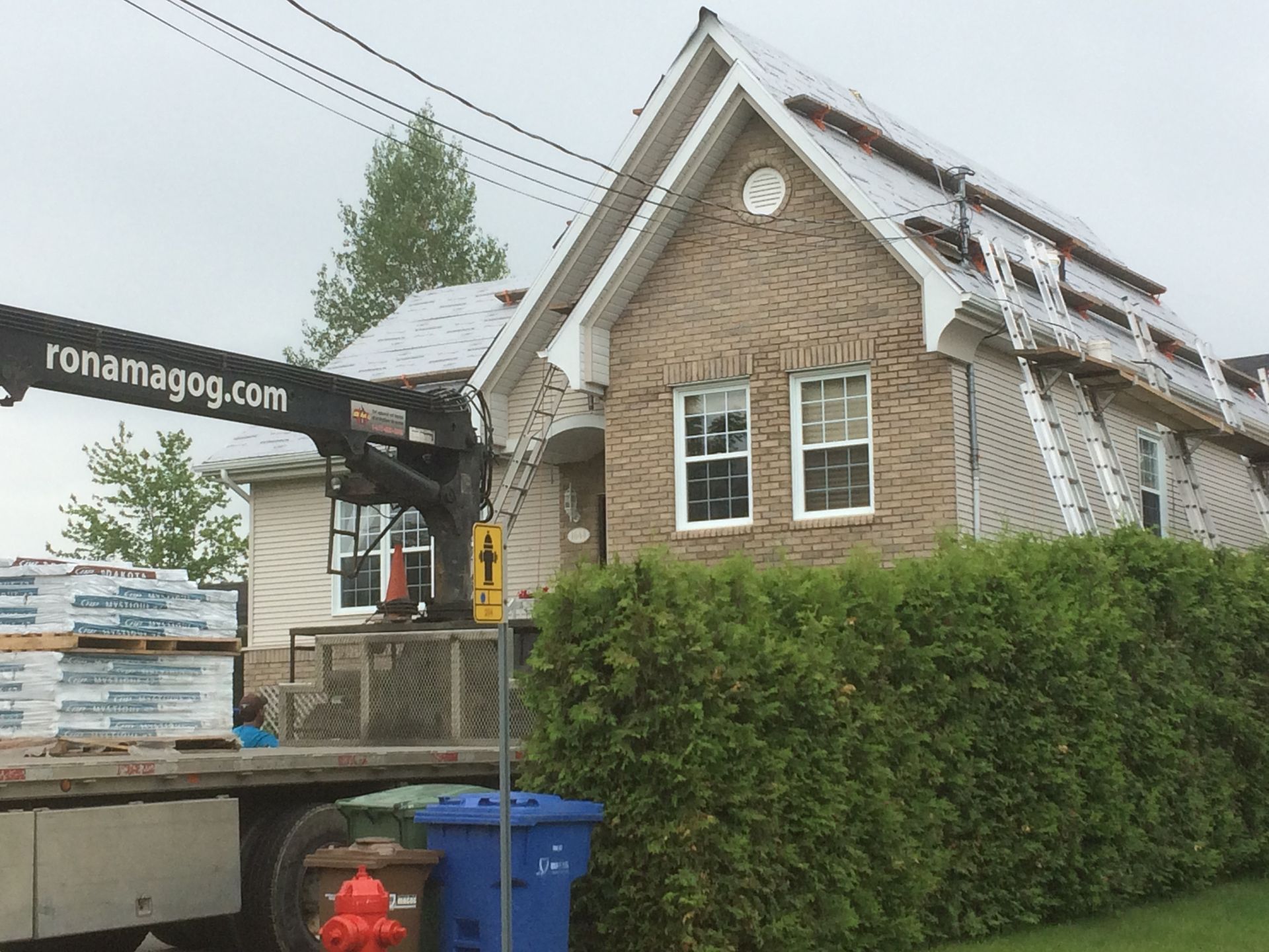 Un camion avec le site Web ronaimagog.com sur le côté est garé devant une maison