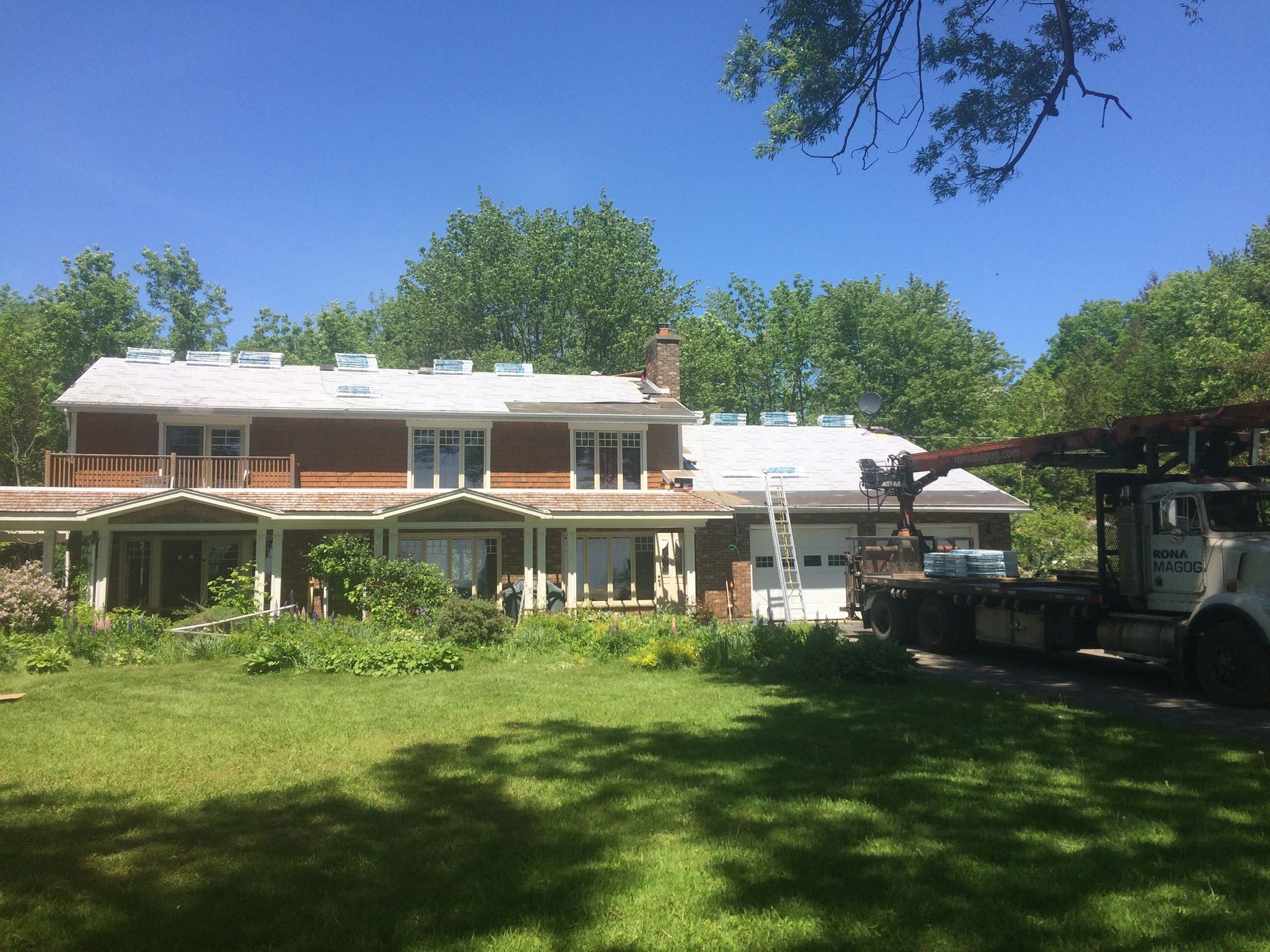 Une grande maison avec un camion garé devant.