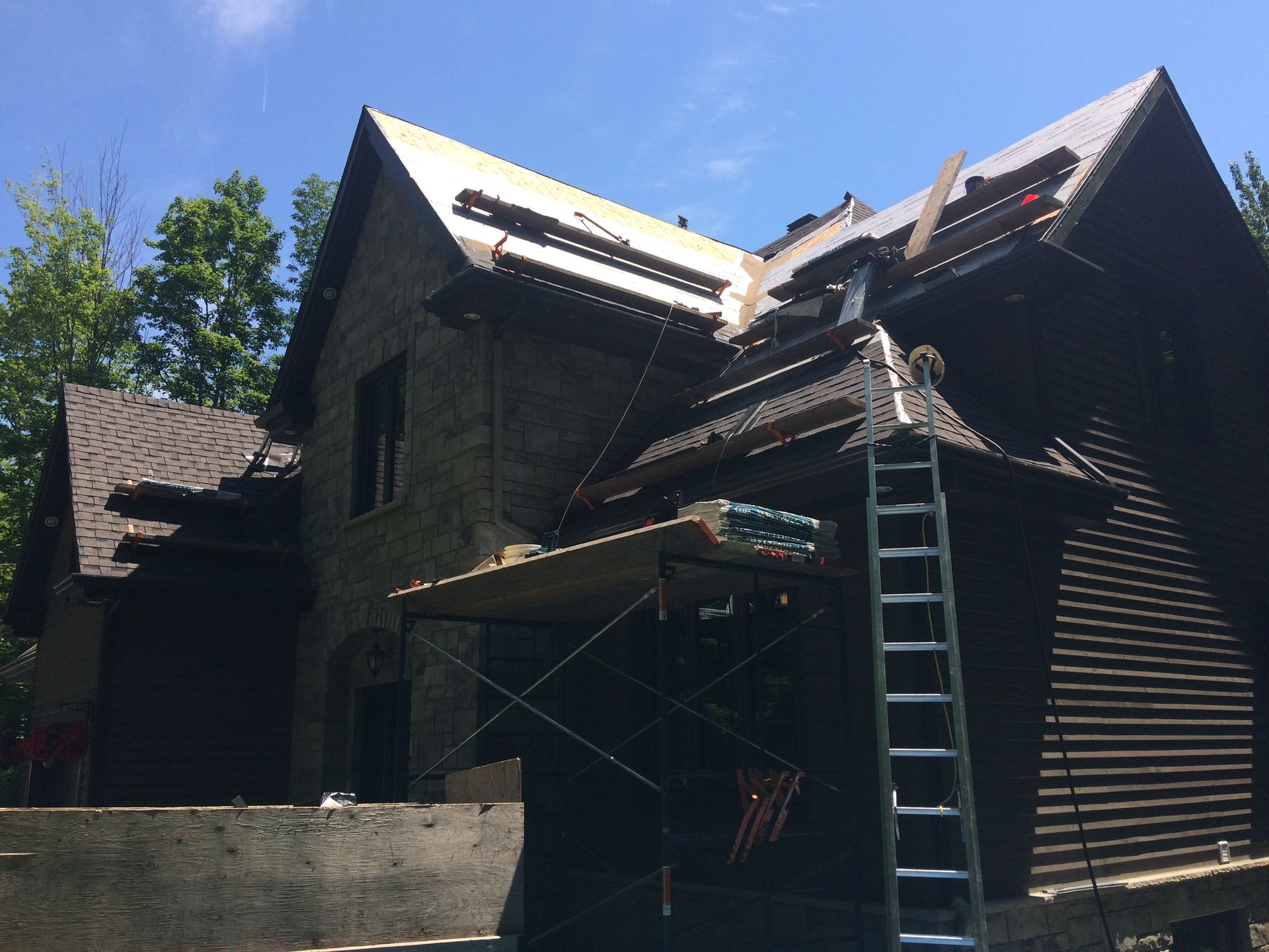 Une échelle est posée sur le côté d'une maison en construction.