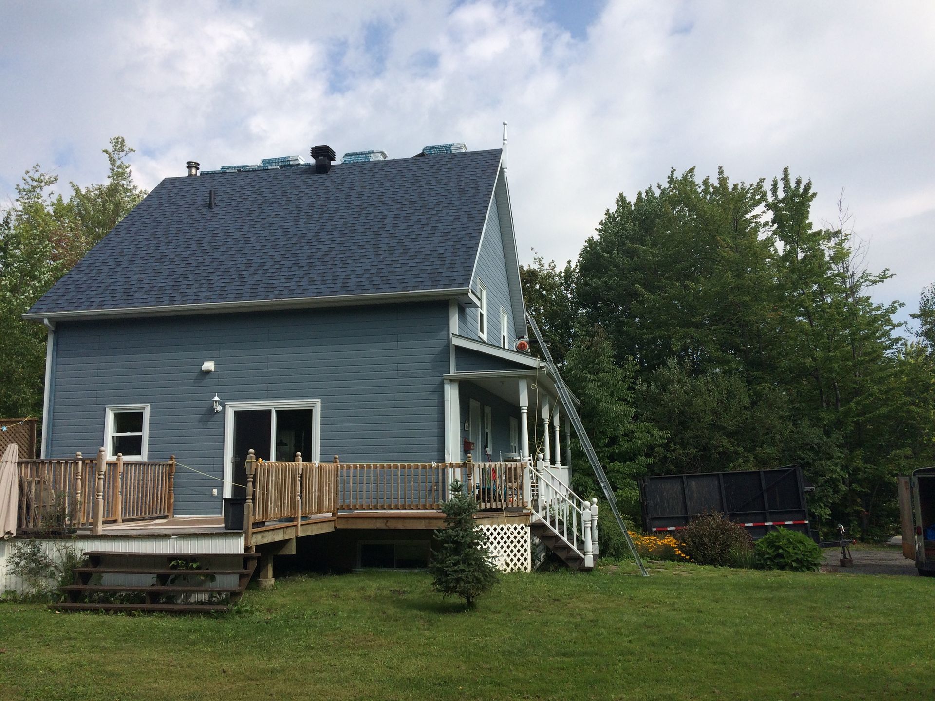 Une maison bleue avec un toit bleu et une terrasse