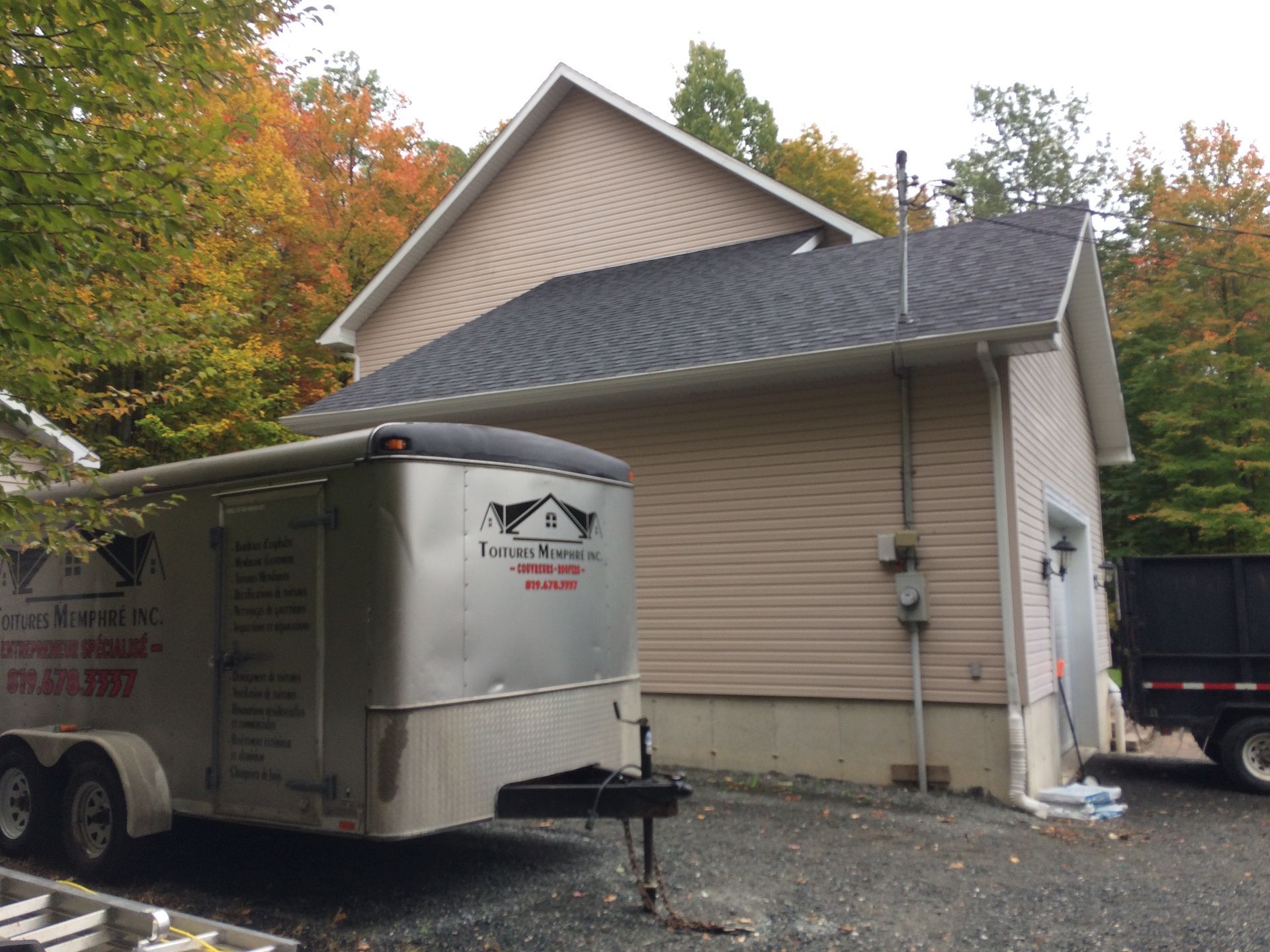 Une remorque est garée devant une maison.