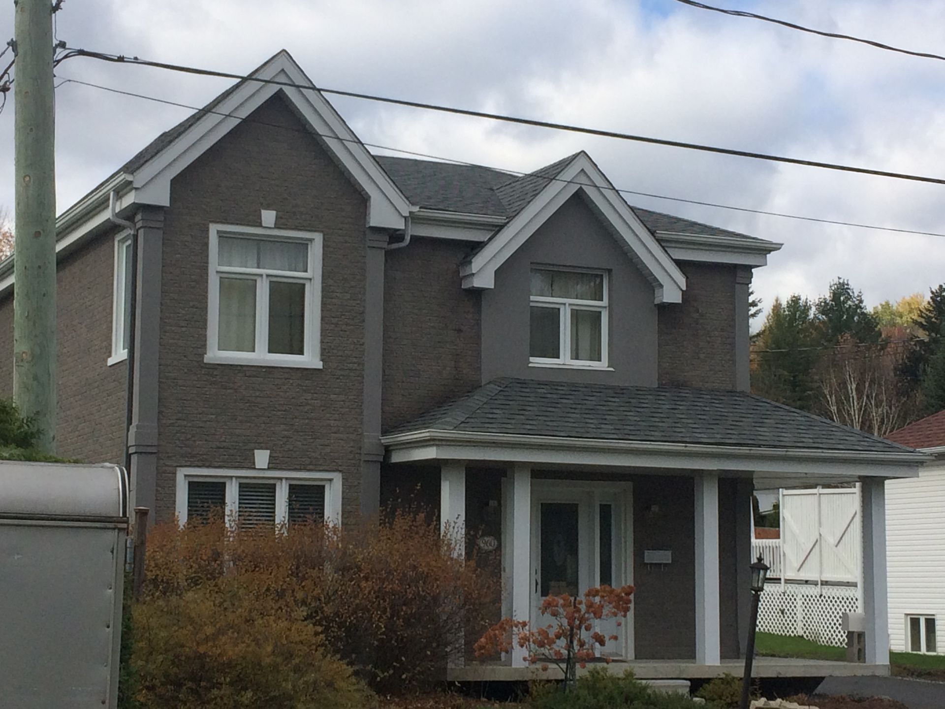 Une grande maison avec un toit gris et des garnitures blanches