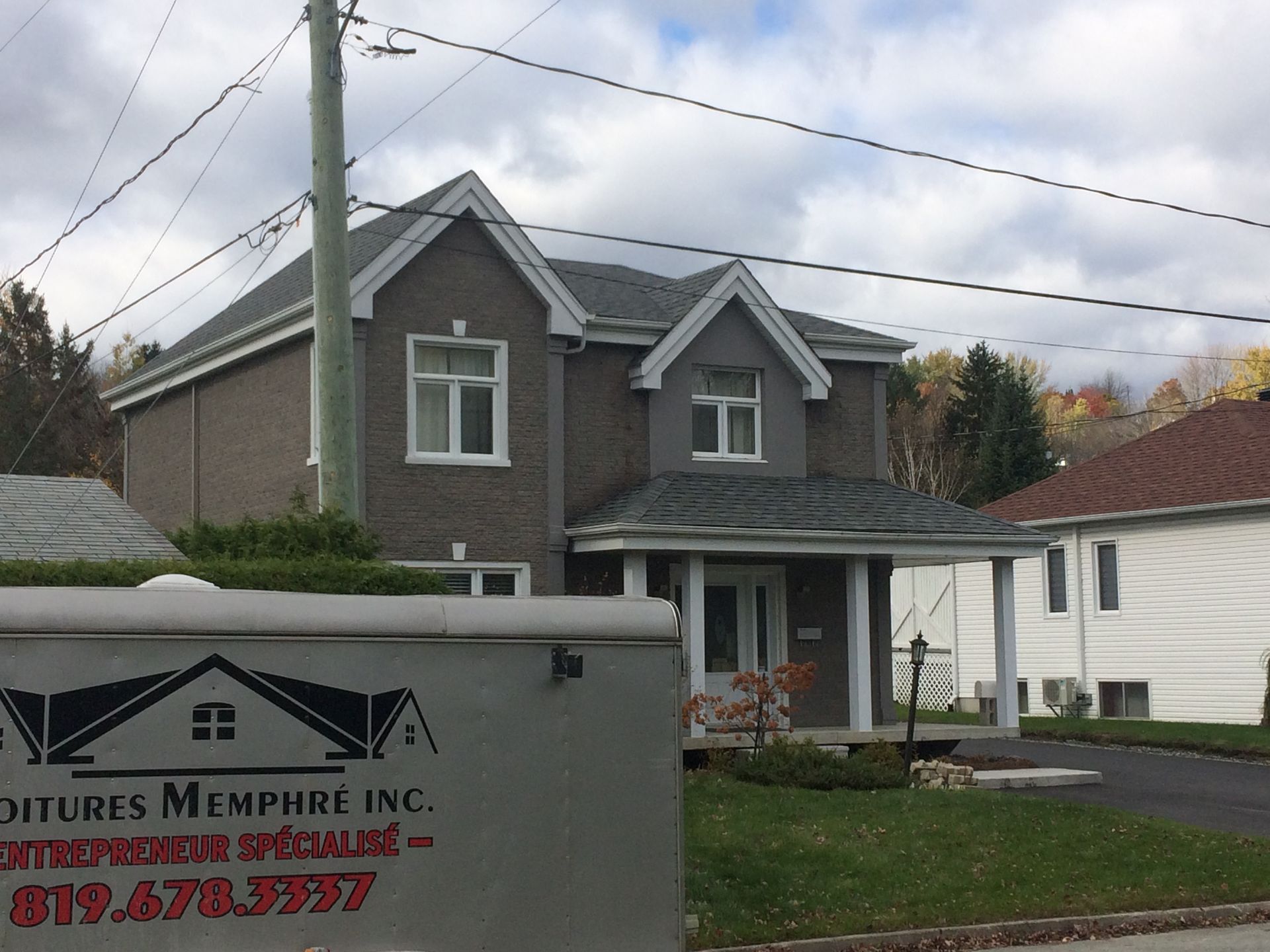 Une maison avec une pancarte devant qui dit peintures memphre inc.