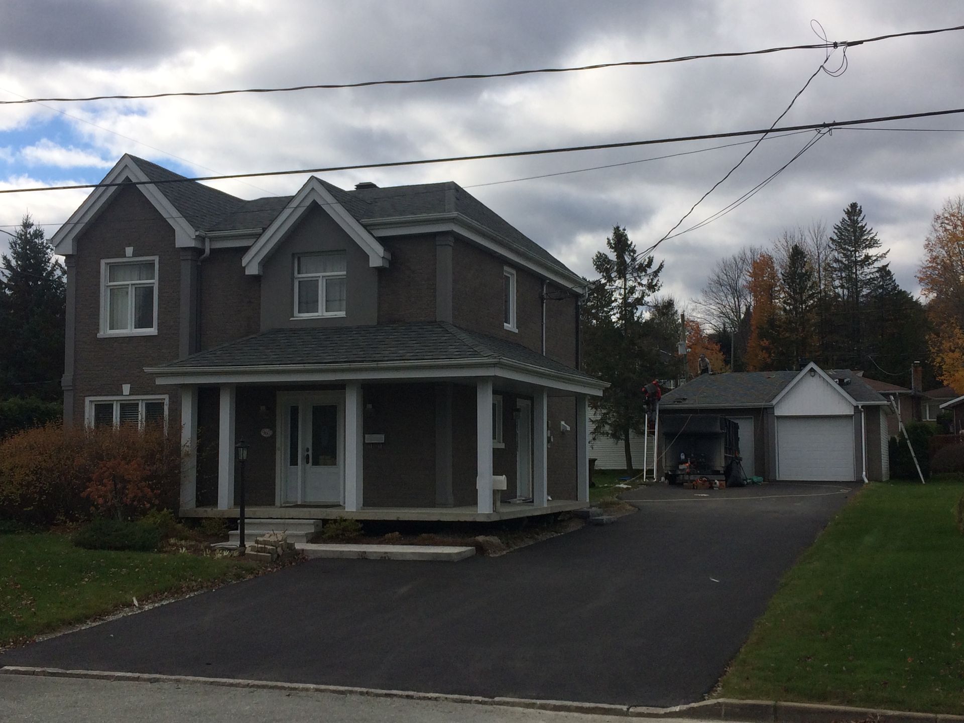Une grande maison avec un porche et un garage