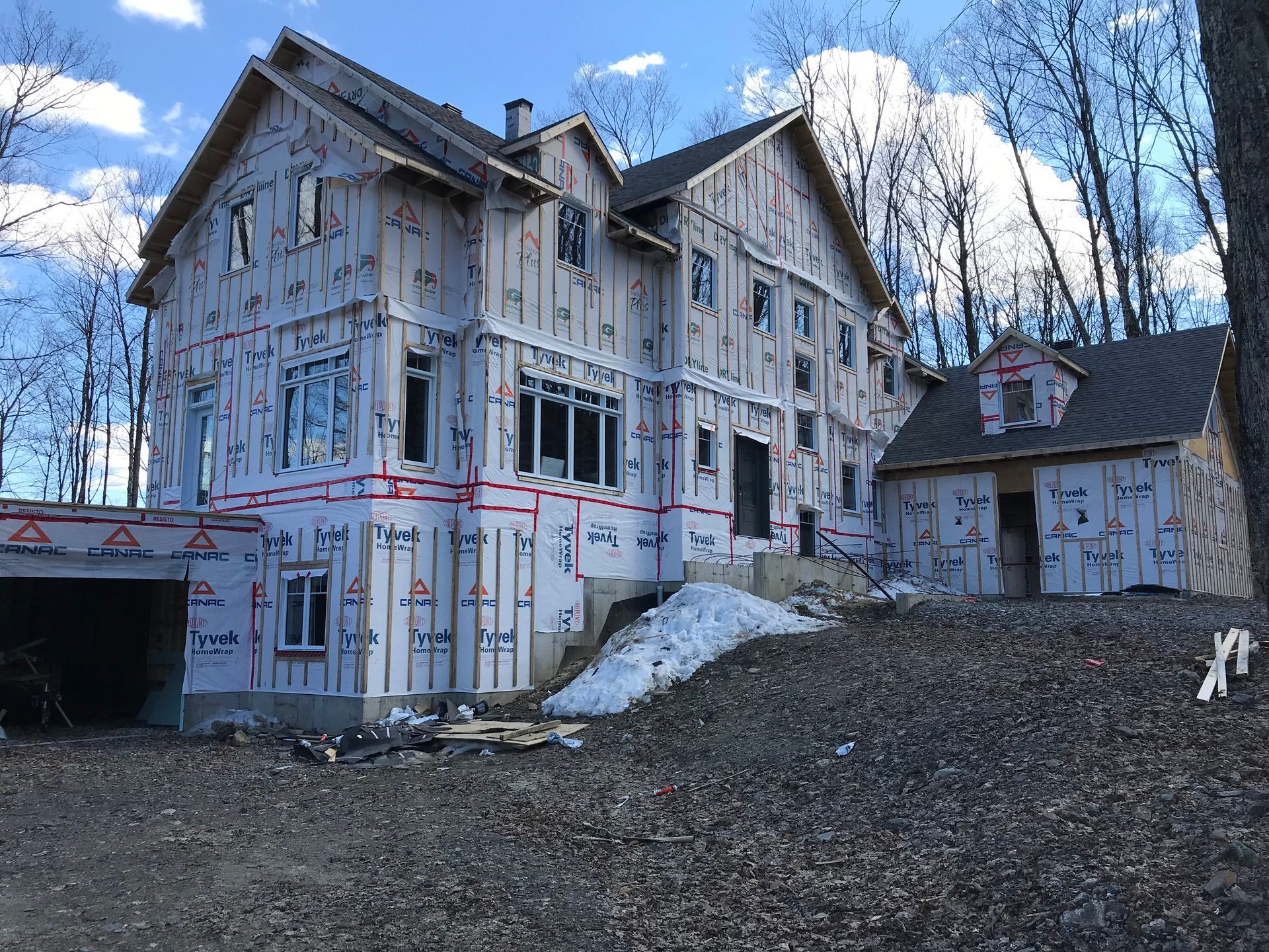 Une grande maison est en construction au milieu d'une forêt.