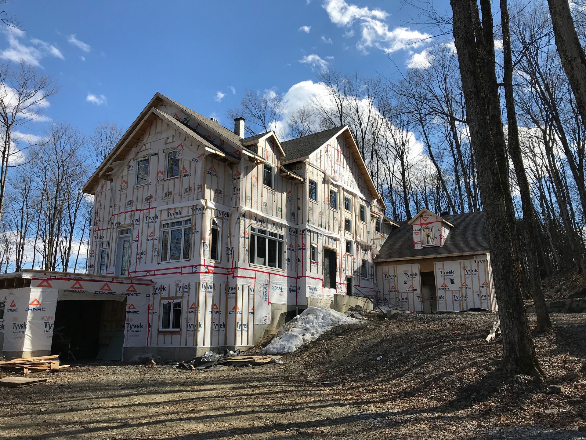 Une grande maison est en construction au milieu d'une forêt.