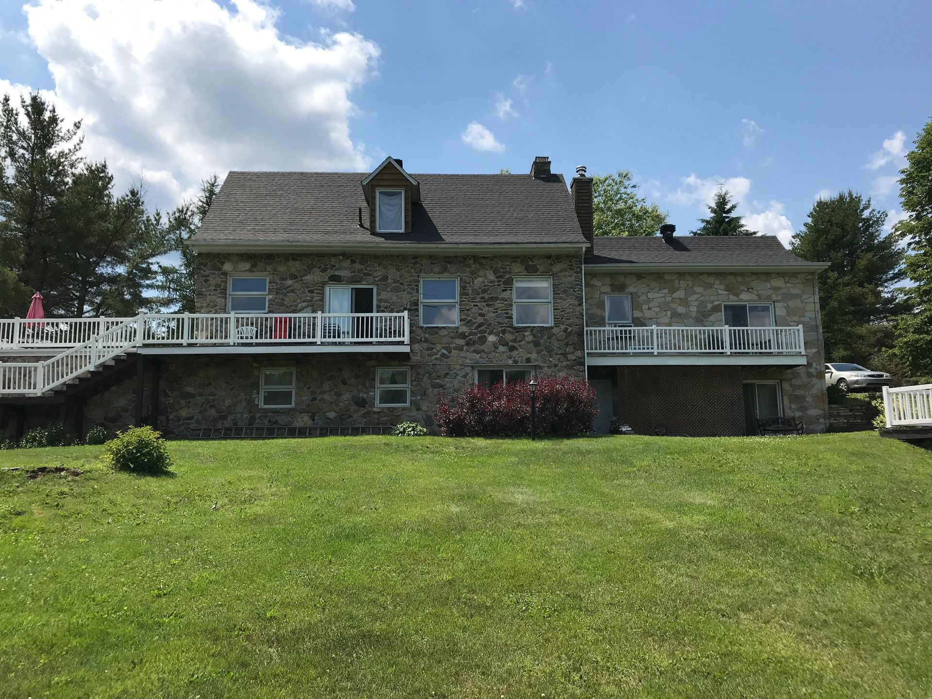 Une grande maison en pierre avec une grande pelouse devant