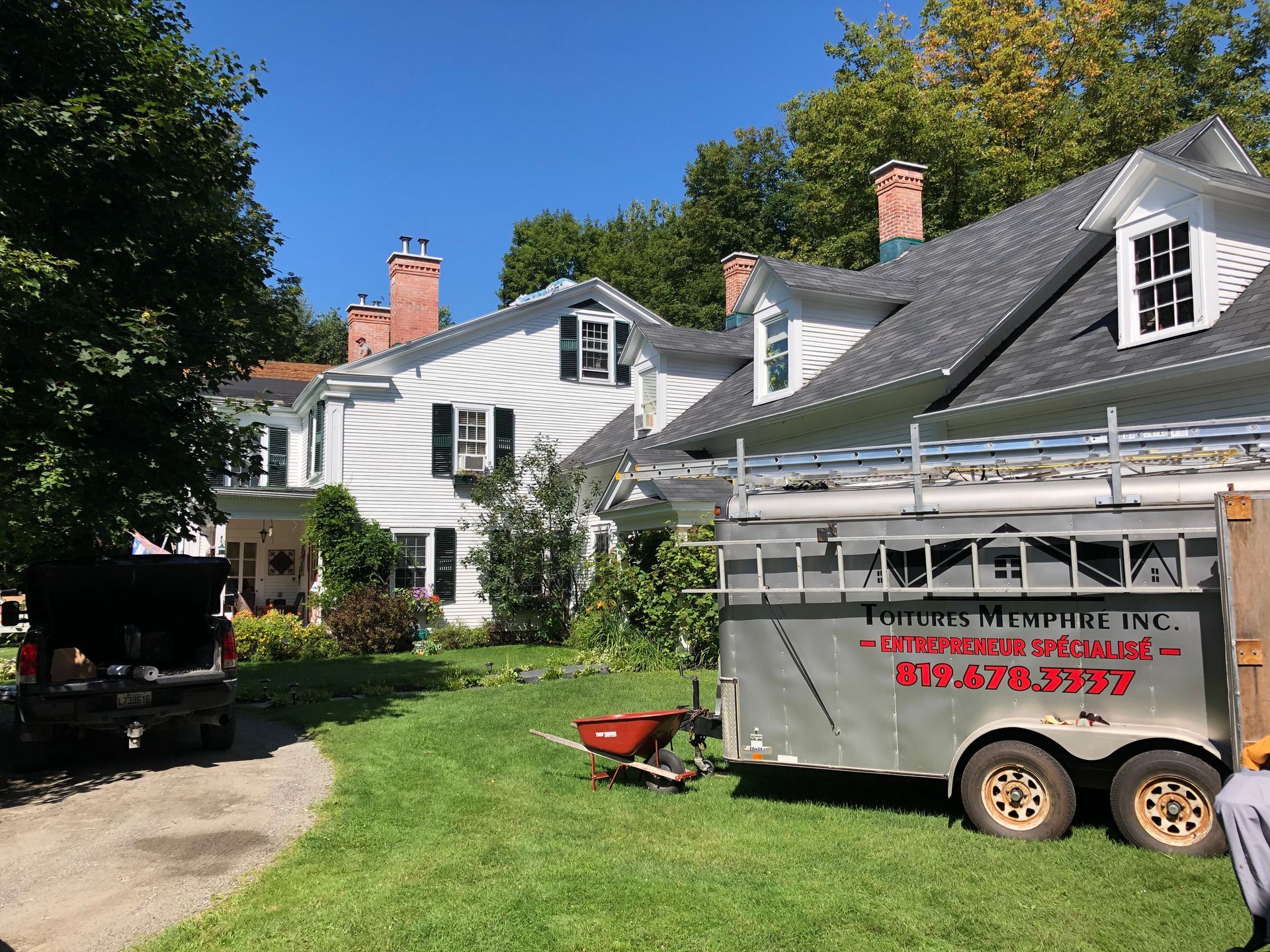 Une remorque est garée devant une maison.