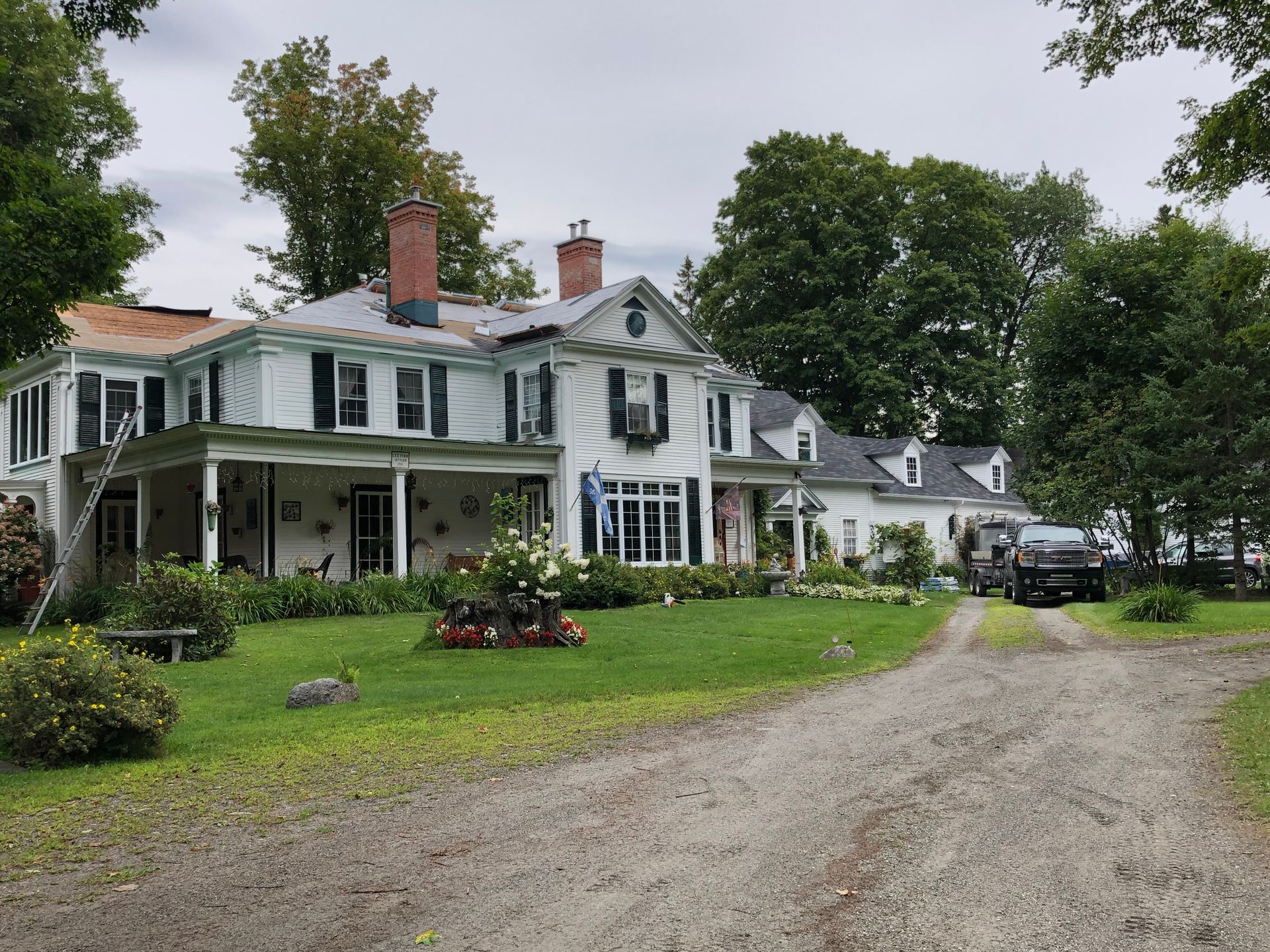 Une grande maison blanche avec une allée qui y mène