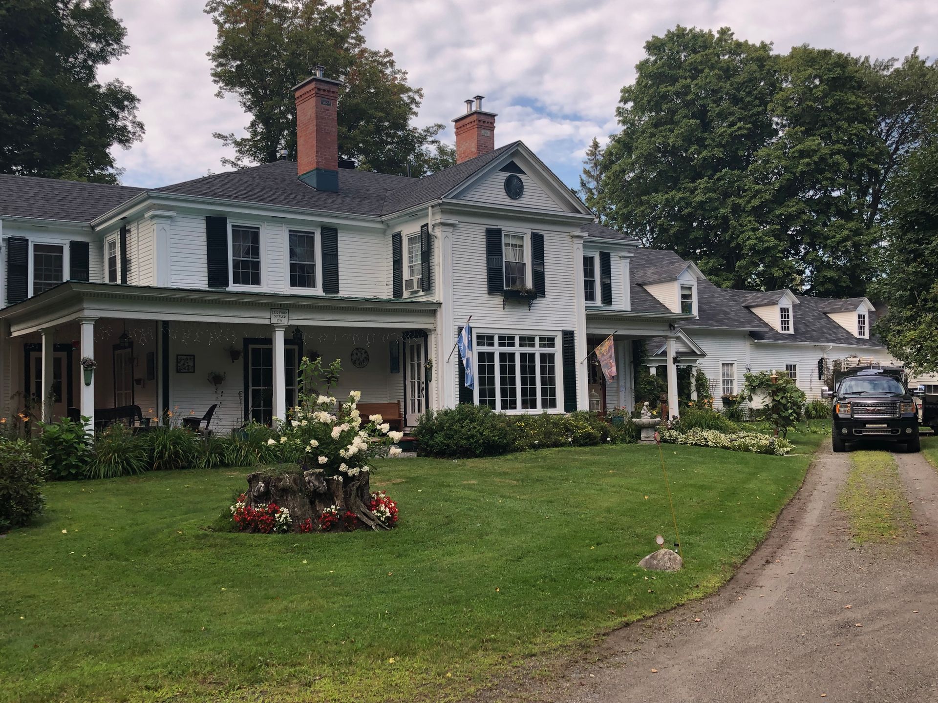 Une grande maison blanche avec une voiture garée devant