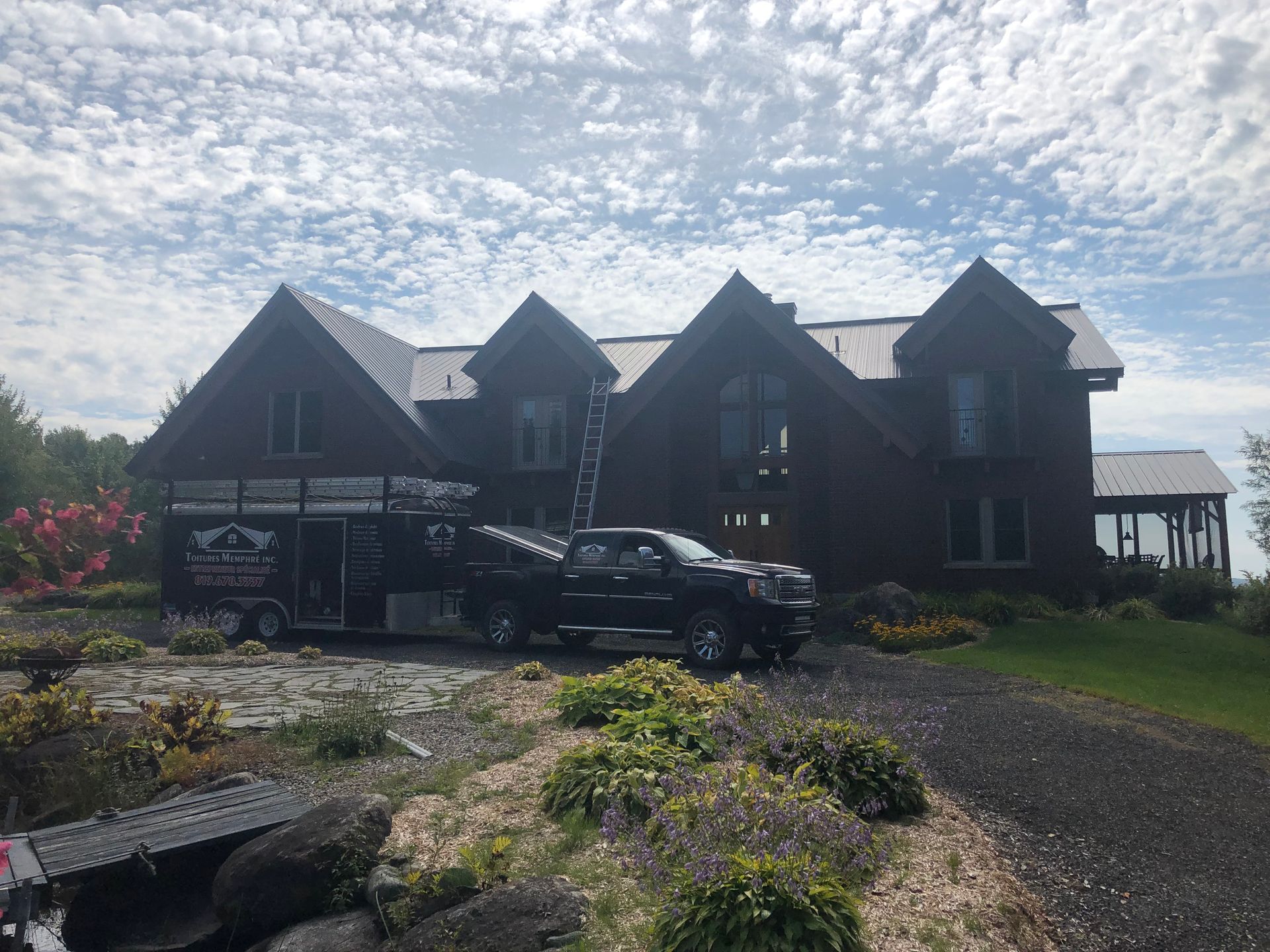 Une grande maison avec un camion garé devant.