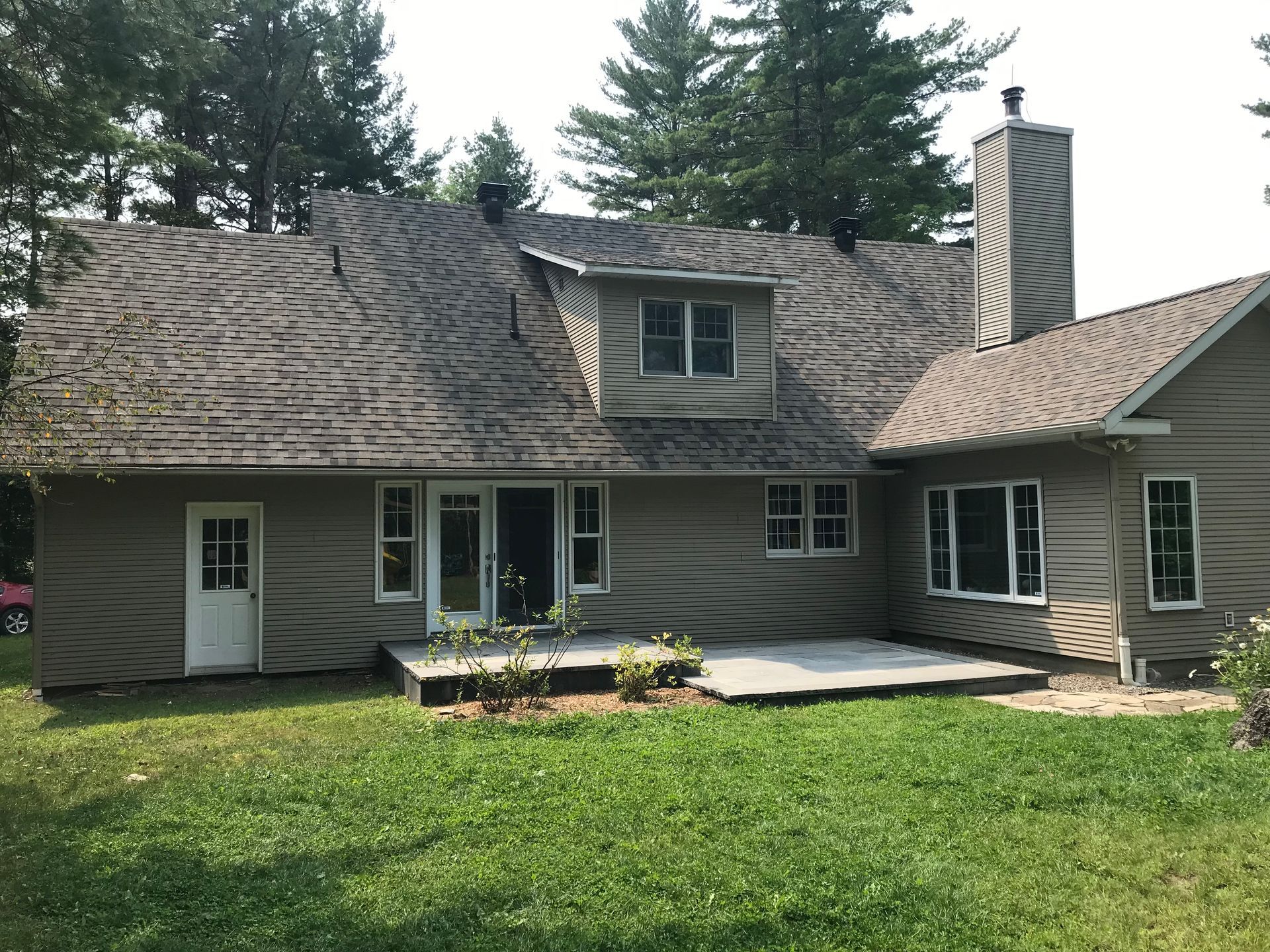 L'arrière d'une maison avec une grande pelouse devant