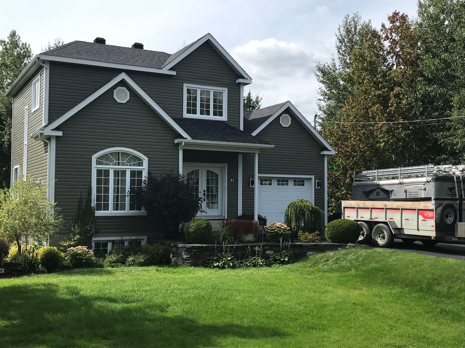 Une grande maison avec une caravane garée devant.
