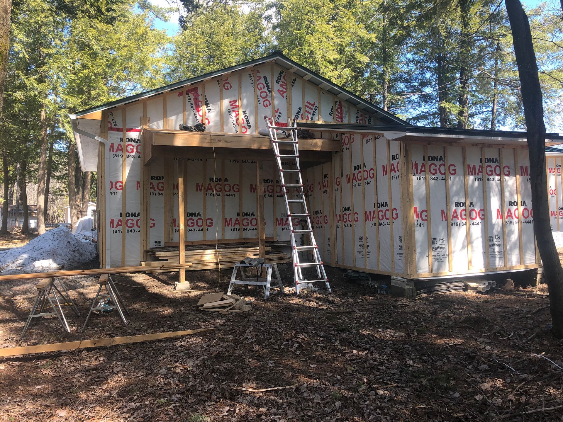 Une échelle est posée sur le côté d'une maison en construction.
