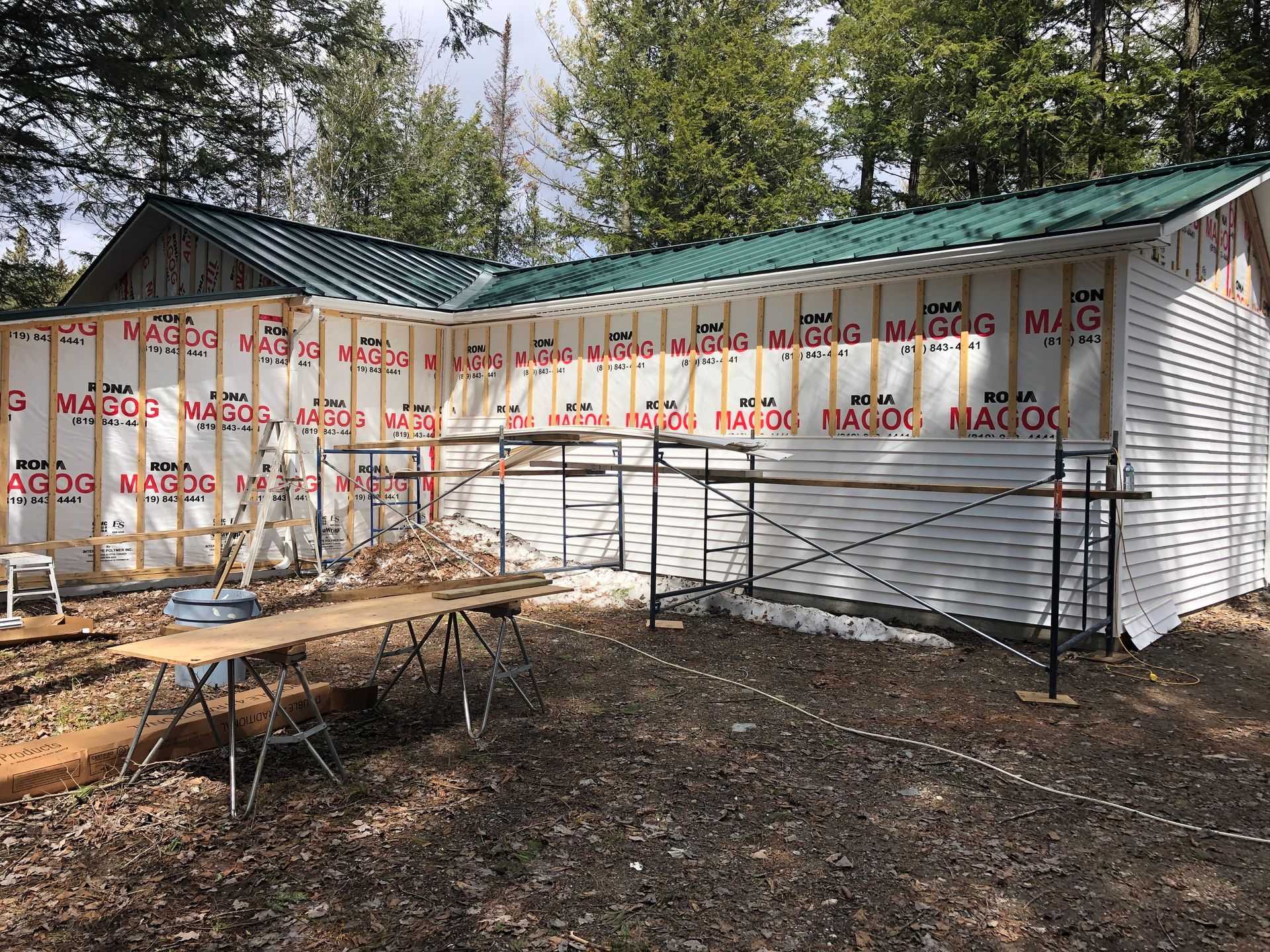 Un grand bâtiment blanc avec un toit vert est en cours de construction.
