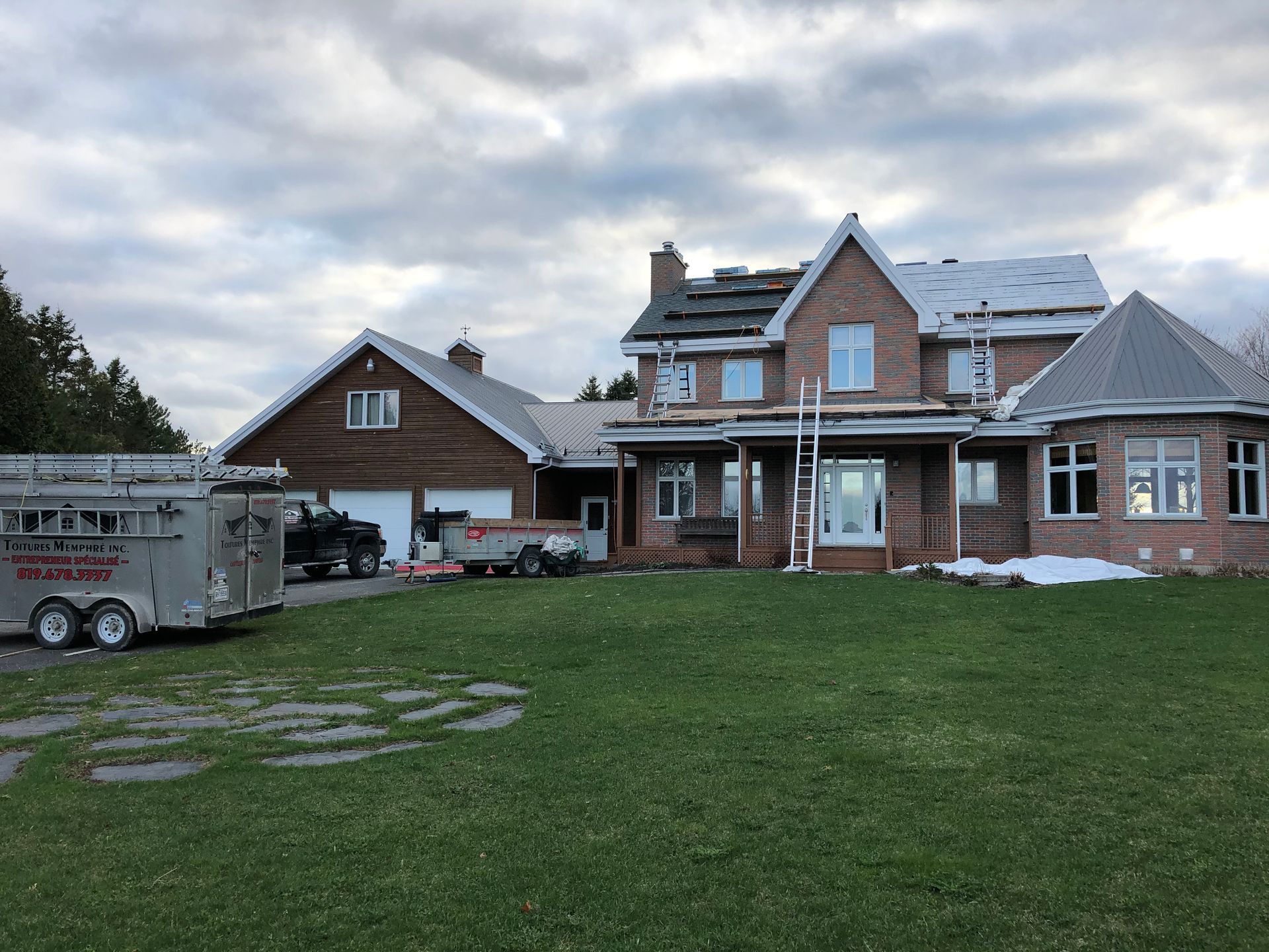 Une grande maison en briques avec une caravane garée devant.