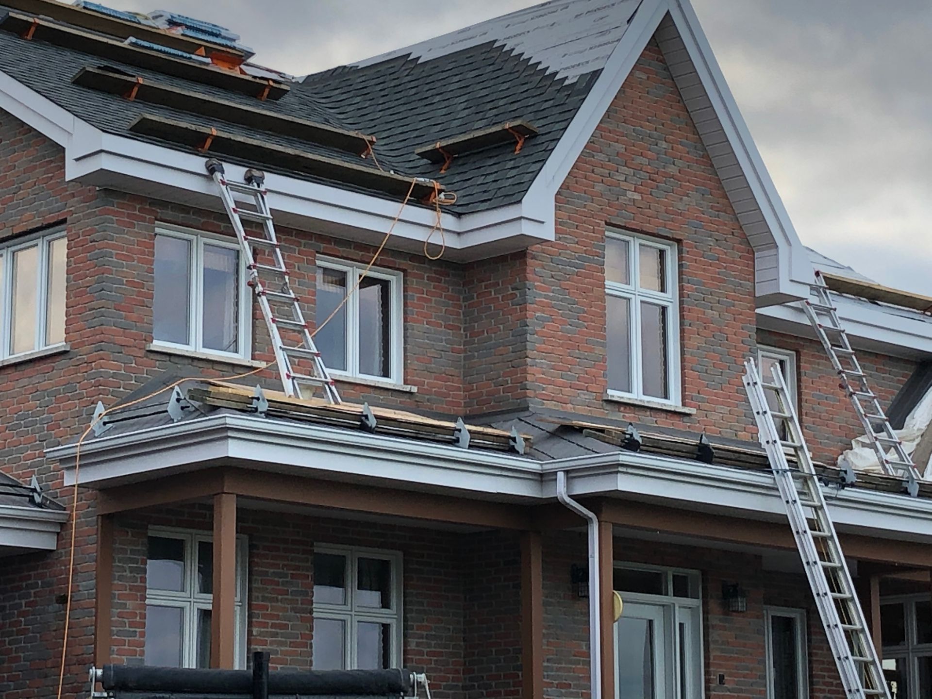 Une maison en briques est en cours de rénovation avec un toit en cours d'installation.