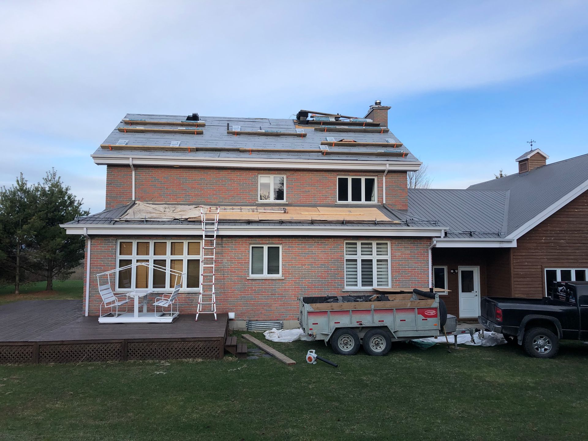 Une maison en briques avec une caravane garée devant