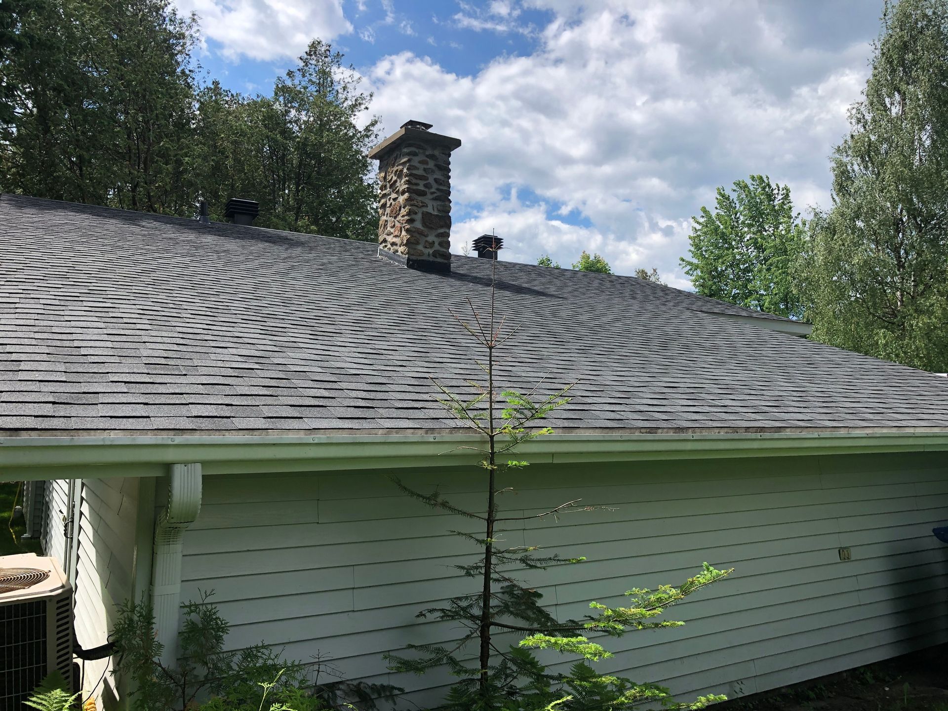 Le toit d'une maison avec une cheminée au-dessus.