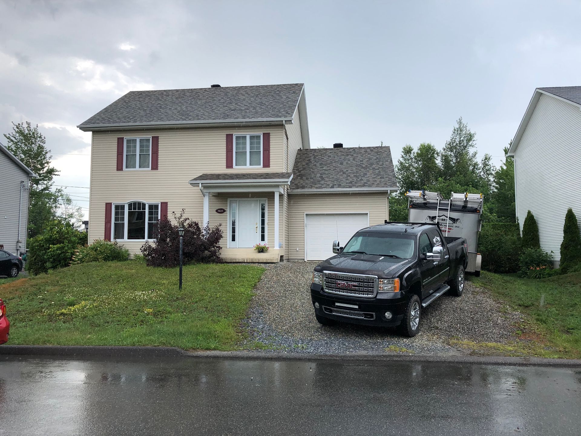 Un camion noir est garé devant une maison.