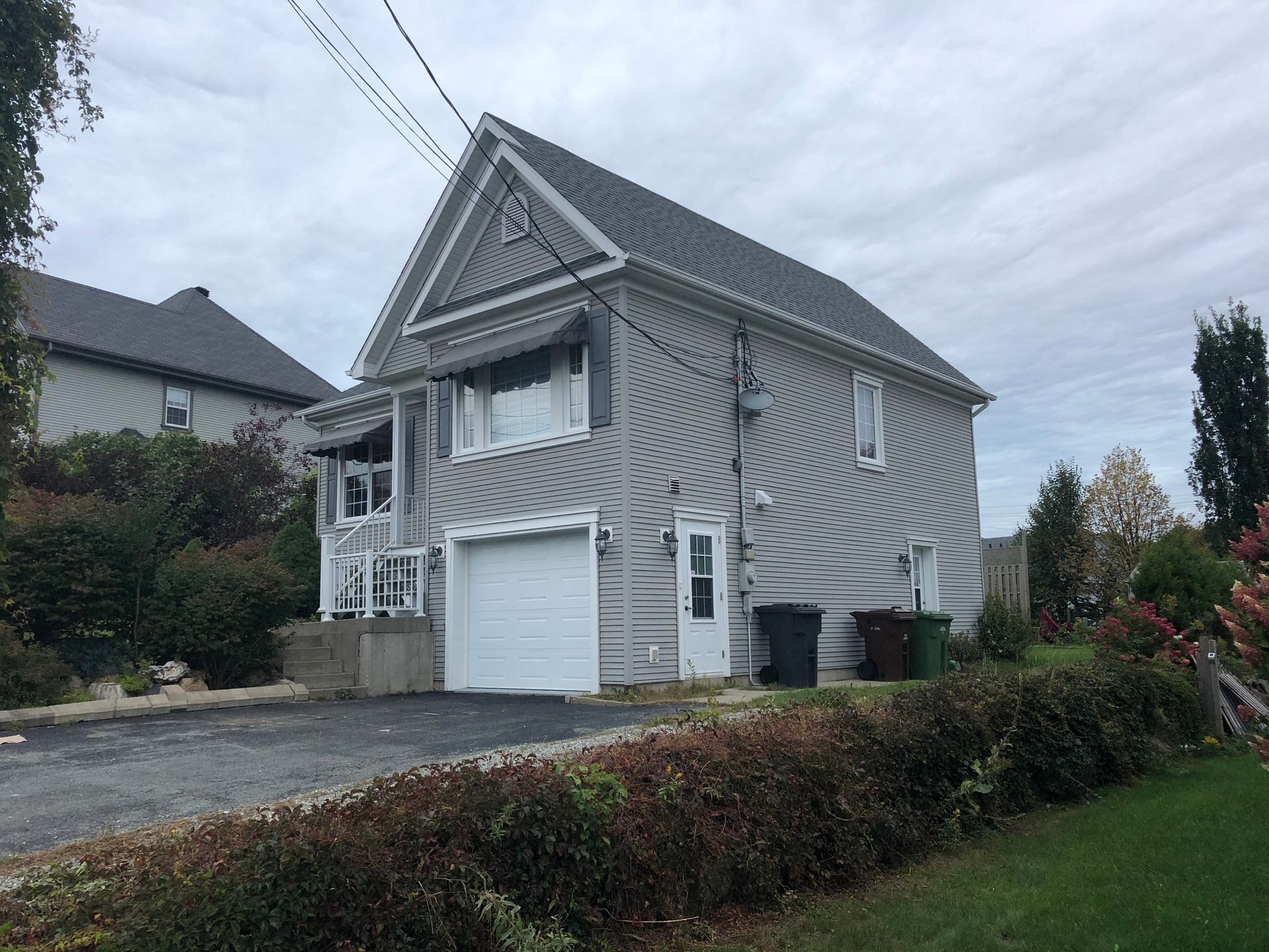 Une grande maison avec un garage et une allée devant.