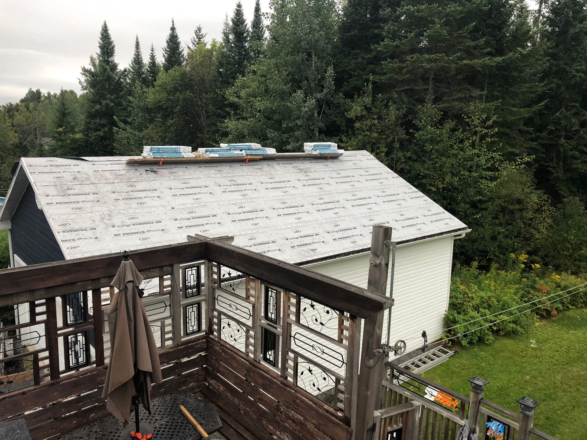 Une vue d'une maison depuis un balcon avec des arbres en arrière-plan.