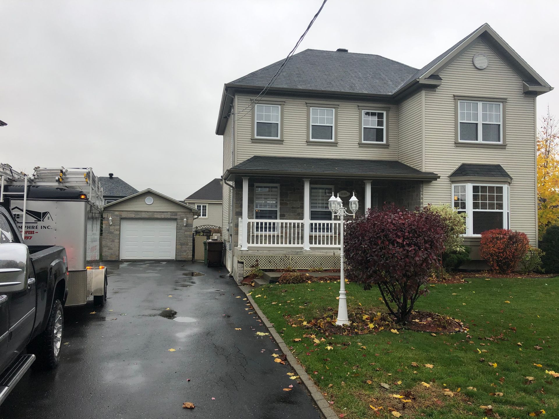 Une grande maison avec un camion garé devant.