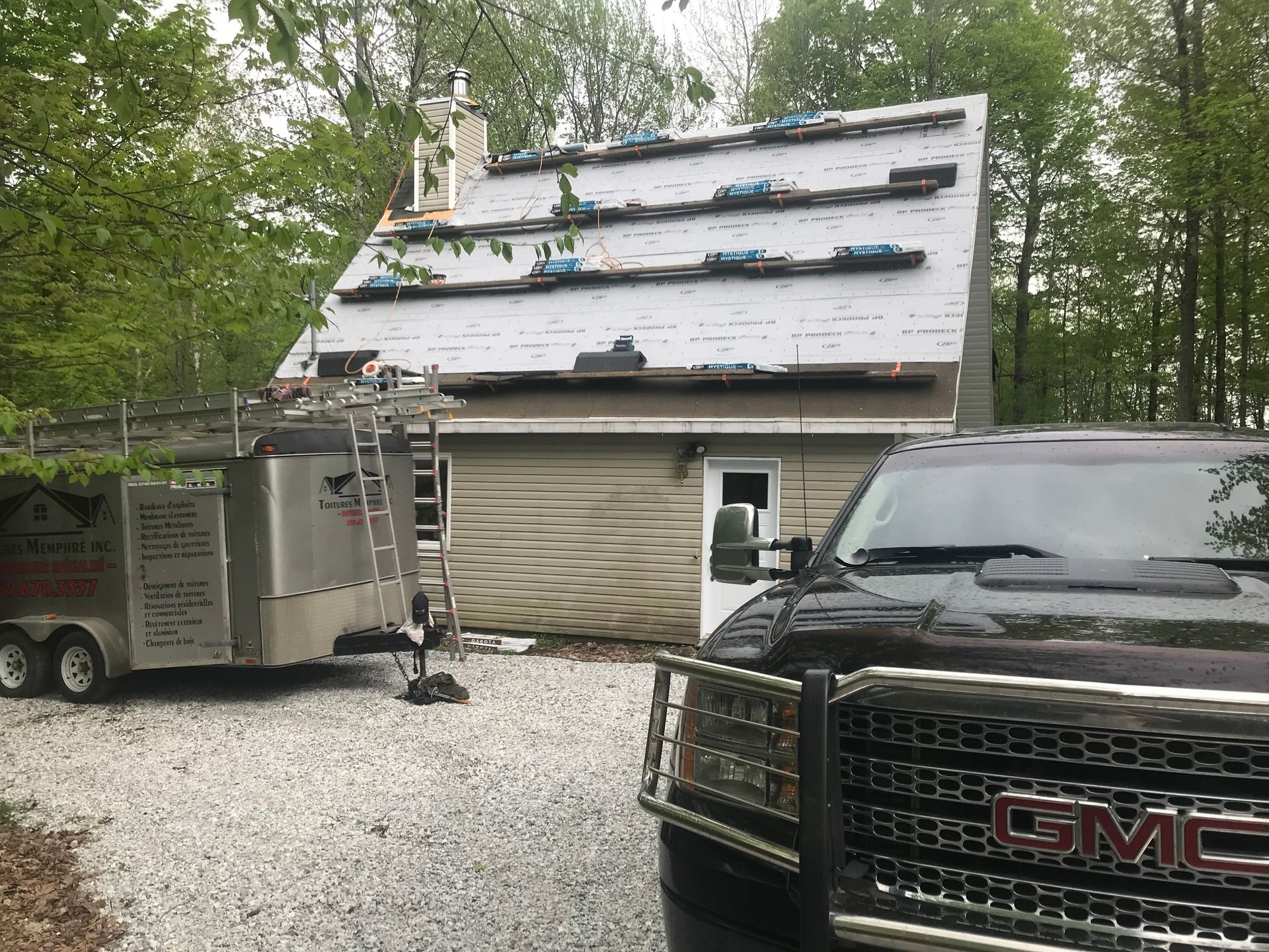 Un camion gmc est garé devant une maison en construction.
