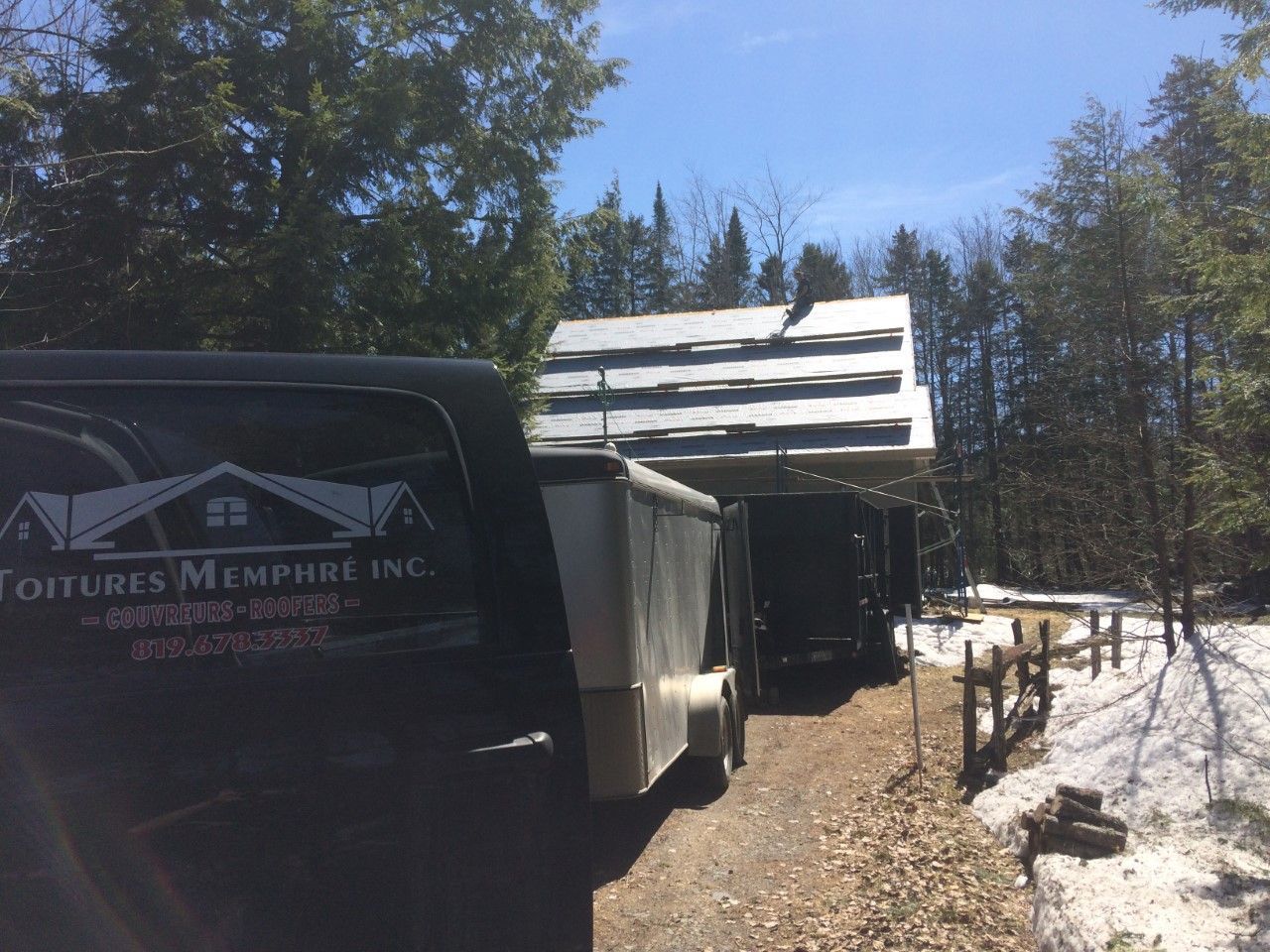 Une camionnette est garée devant une maison avec une remorque attachée.